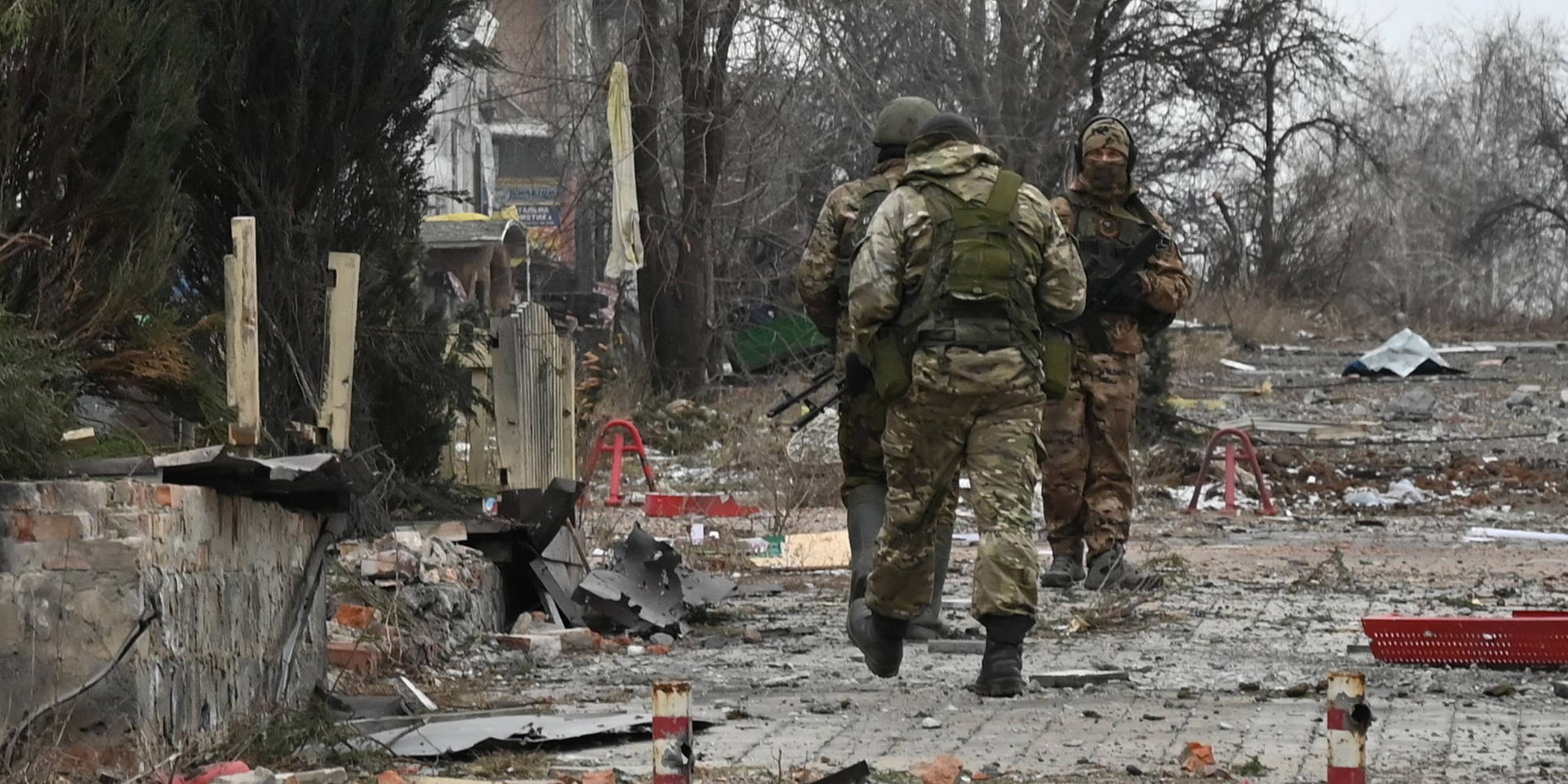 Militärangehörige des russischen privaten Militärunternehmens Wagner Group laufen in einer Straße von Soledar
