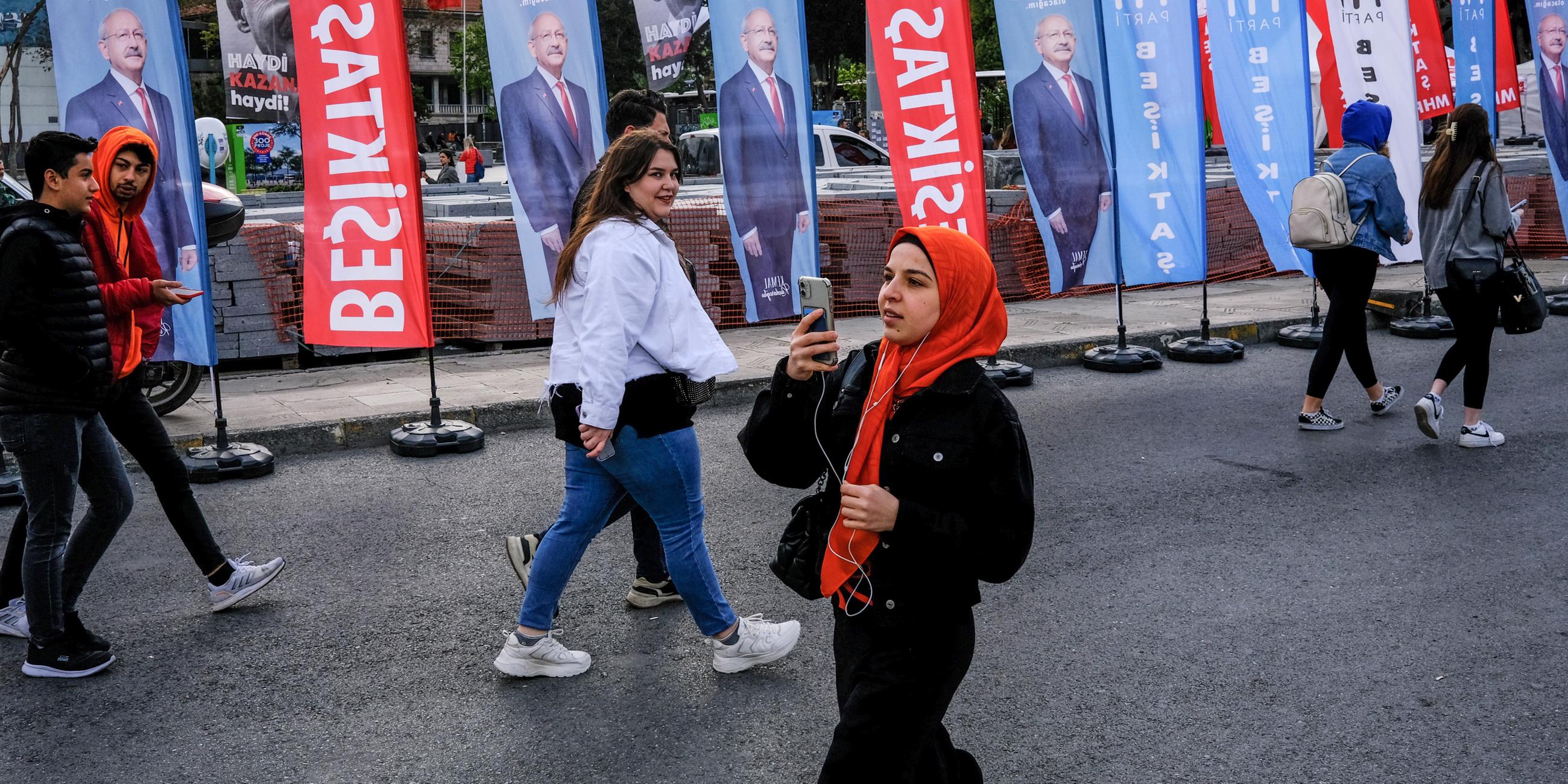 Junge Menschen gehen vor den Bildern des türkischen Präsidentschaftskandidaten Kemal Kilicdaroglu, aufgenommen am 10.05.2023 in Istanbul