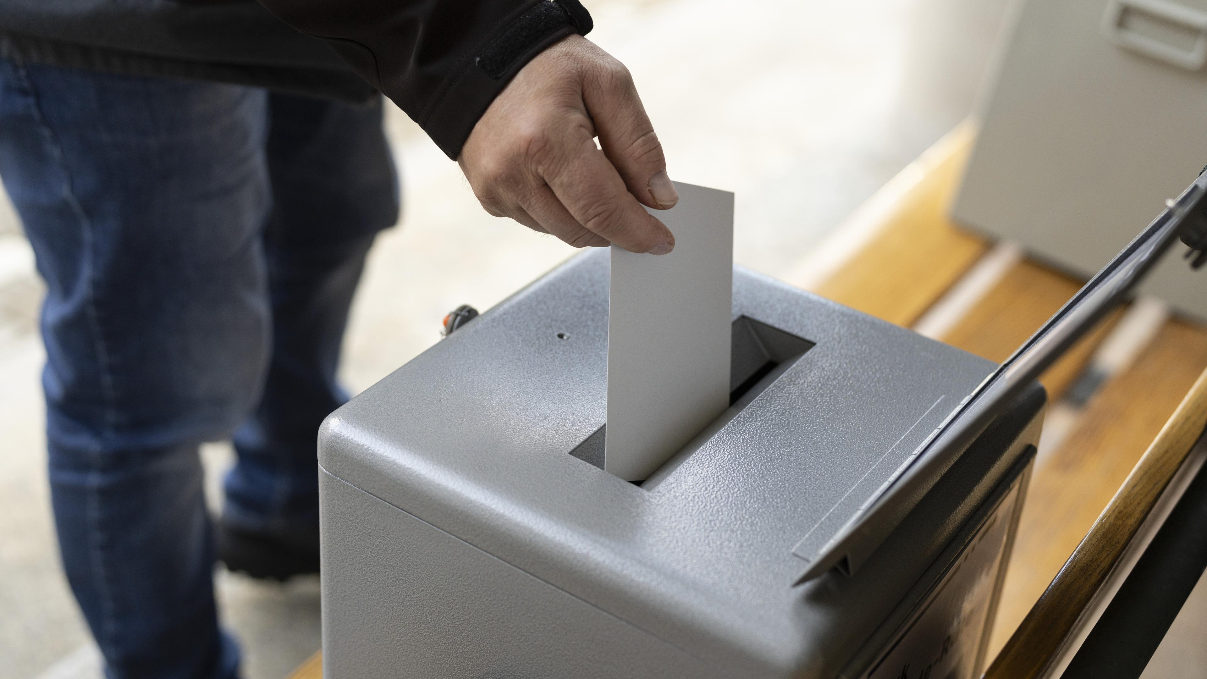 Schweiz, Appenzell: Personen werfen ihren Wahlzettel in die Wahlurne fuer die eidgenoessischen Wahlen am Sonntag, 22. Oktober 2023 in Appenzell.