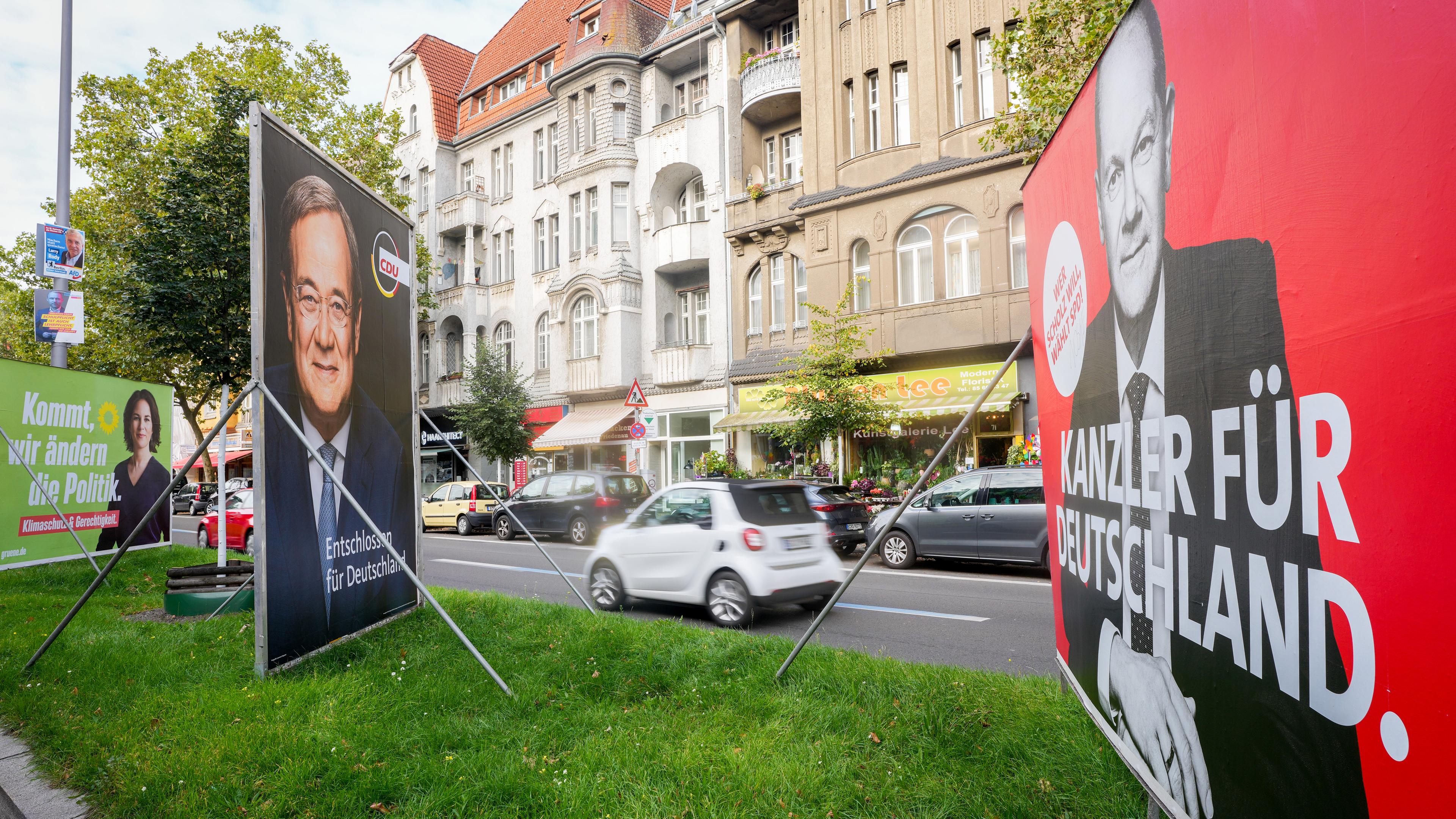 Archiv: Ein Auto fährt an Wahlplakaten mit den Kanzlerkandidaten von SPD mit Olaf Scholz, von CDU mit Armin Laschet und Bündnis 90/Die Grünen mit Annalena Baerbock vorbei. 