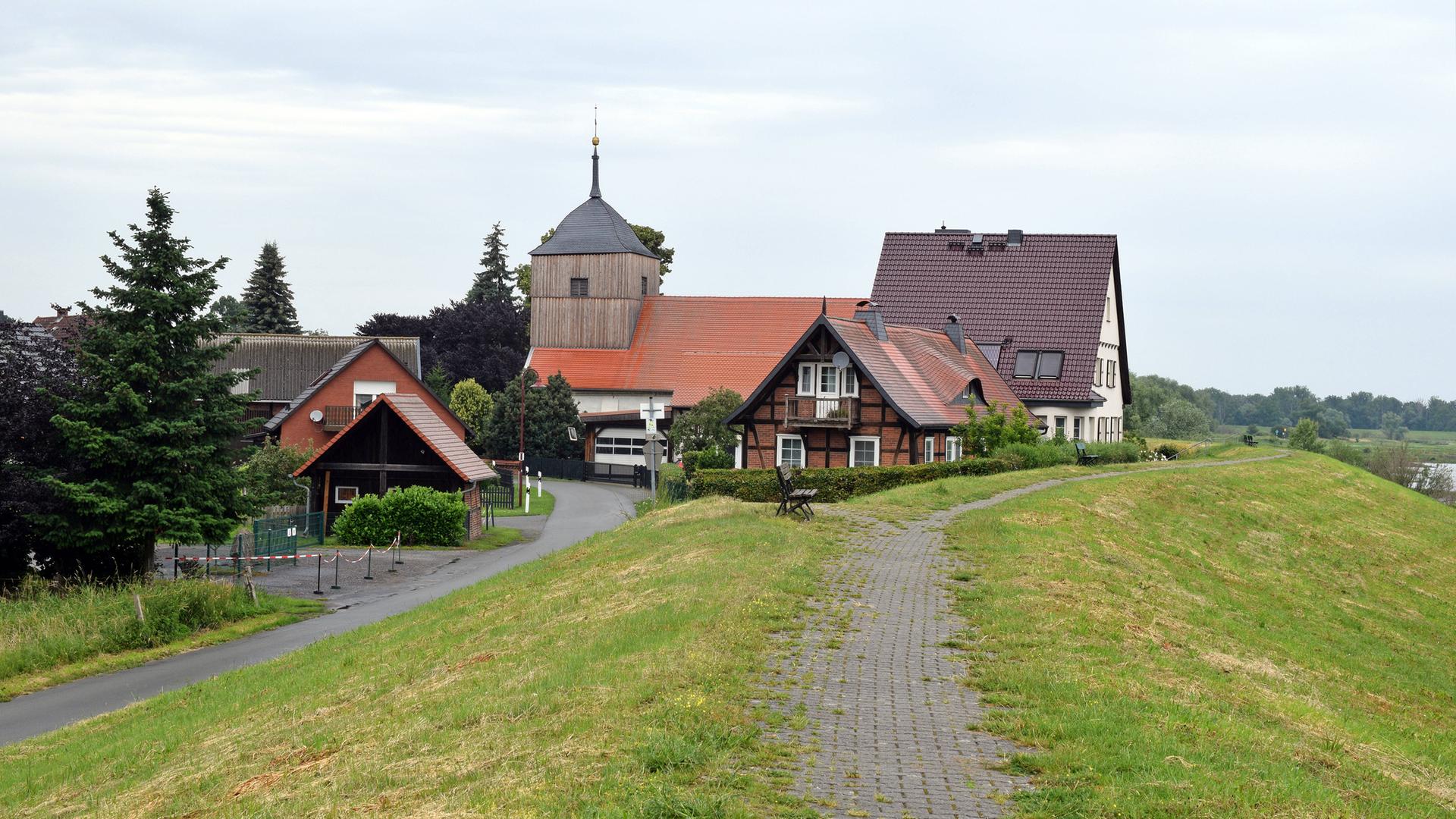 Fachwerkhäuser stehen an einem Deich