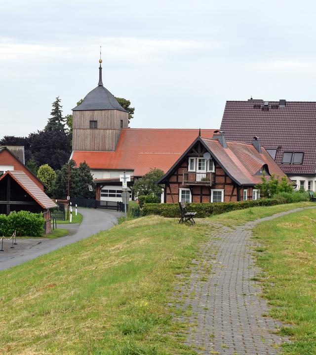 Fachwerkhäuser stehen an einem Deich