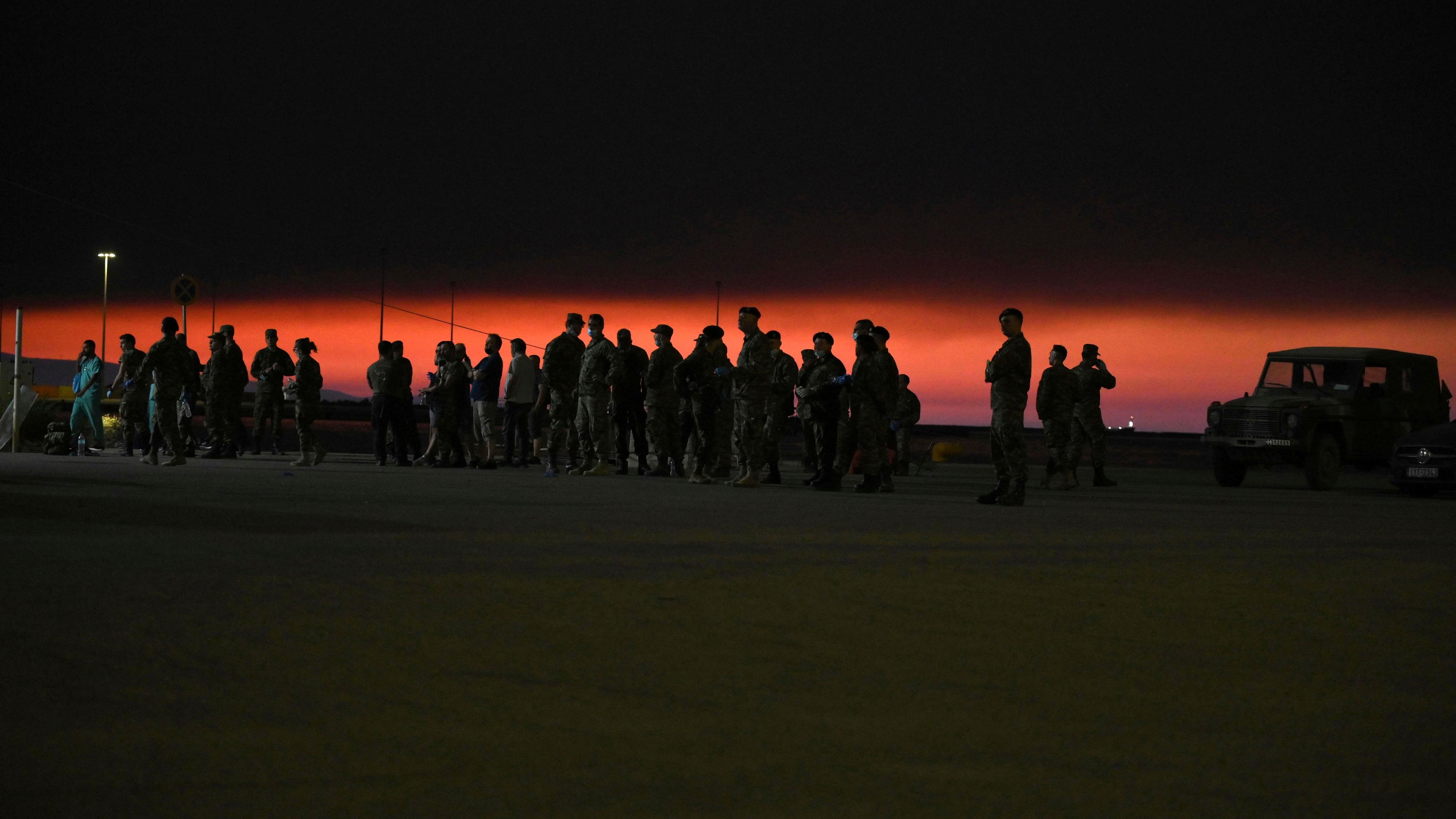  Armeeangehörige stehen an einem Hafen, während Rauch in Alexandroupolis in der nordöstlichen Region Evros, Griechenland.