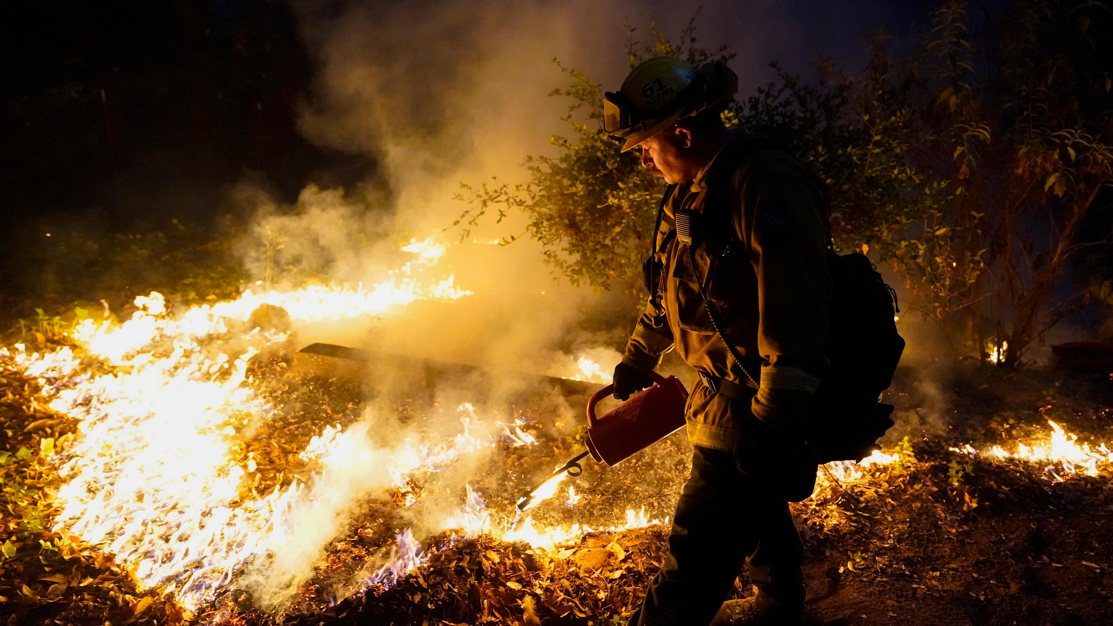 Ein Feuerwehrmann brennt gezielt Waldflächen ab