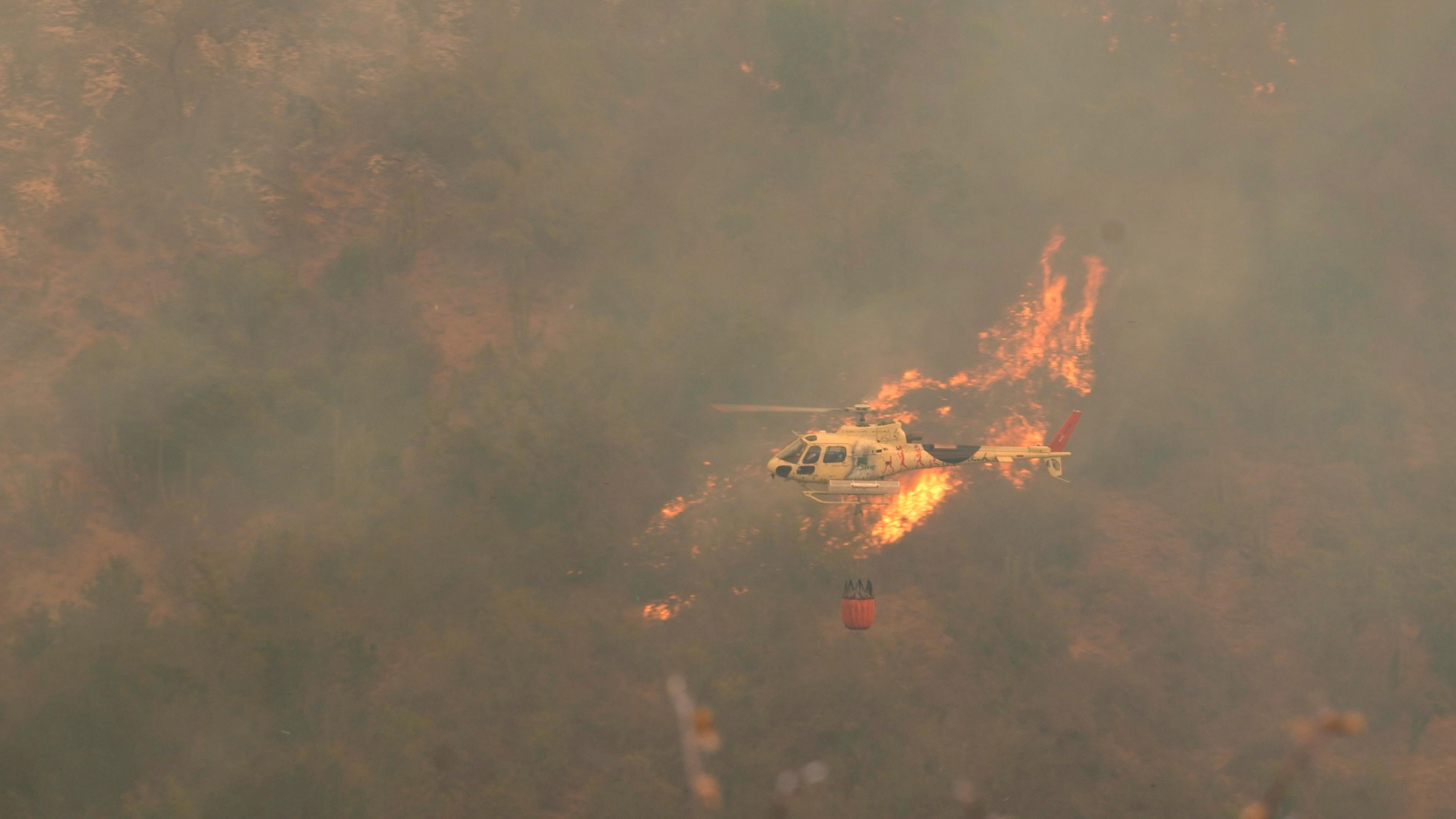 Chile, Vina del Mar: Ein Hubschrauber fliegt über einen Waldbrand, der sich ausgebreitet hat. 