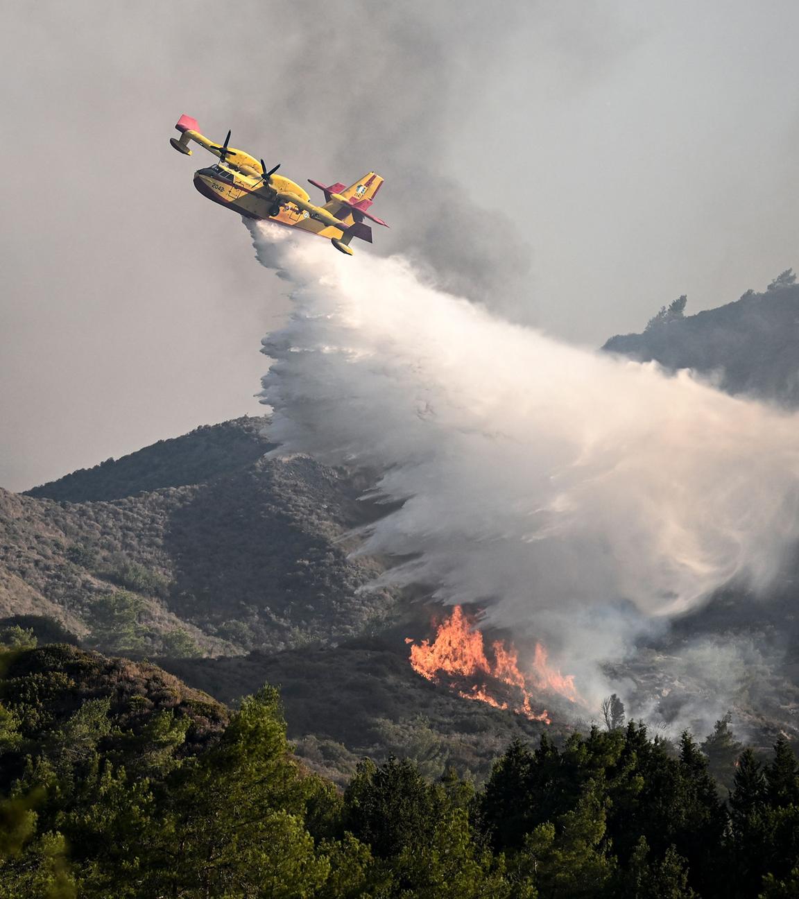 Ein Löschflugzeug wirft am 25. Juli 2023 Wasser über einem Waldbrand in der Nähe des Dorfes Vati im Süden der griechischen Insel Rhodos, aufgenommen am 24.07.2023
