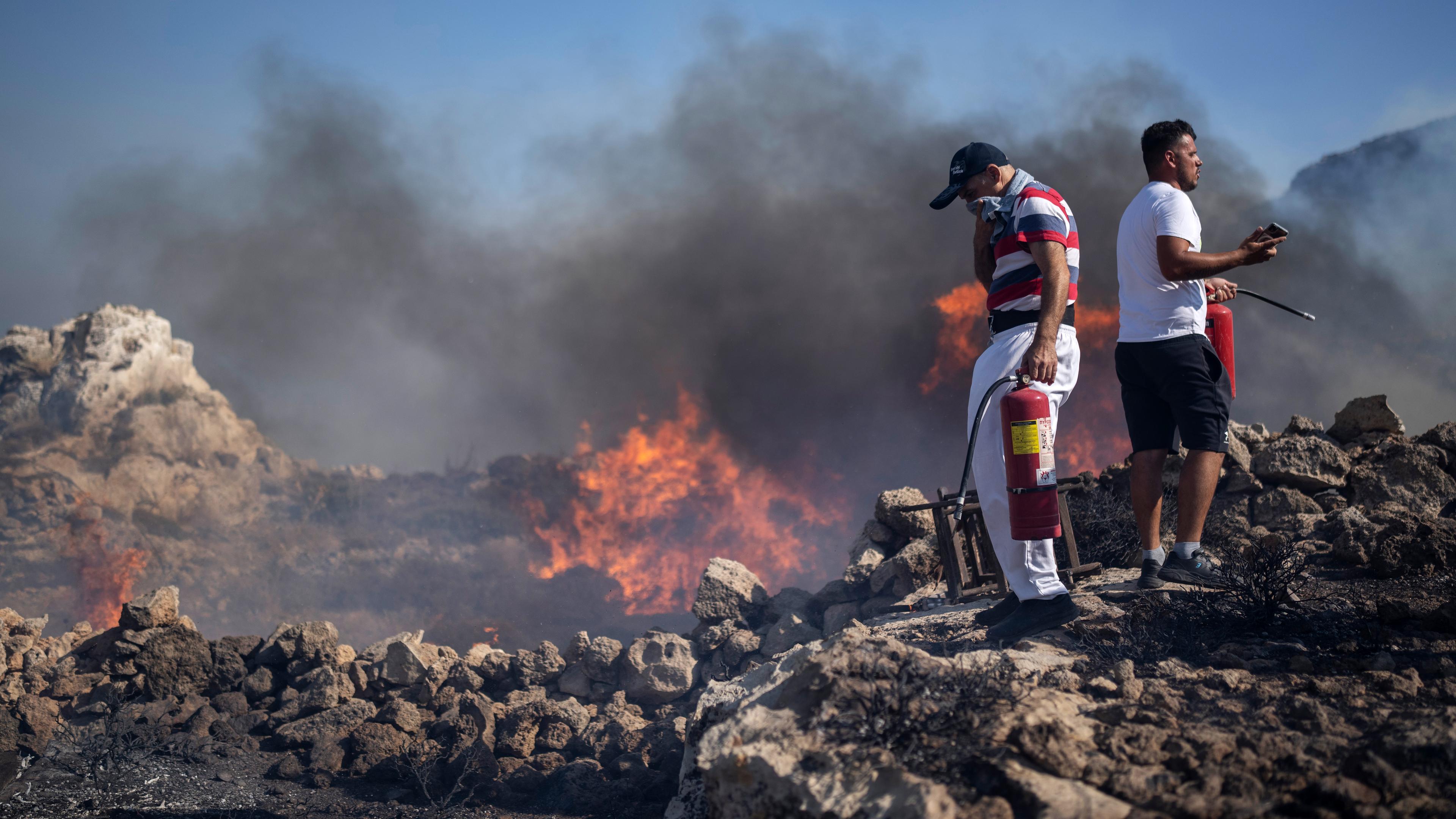 Anwohner versuchen in der Nähe des Badeortes Lindos auf der Insel Rhodos mit Feuerlöschern ein Feuer zu löschen, aufgenommen am 24.07.2023