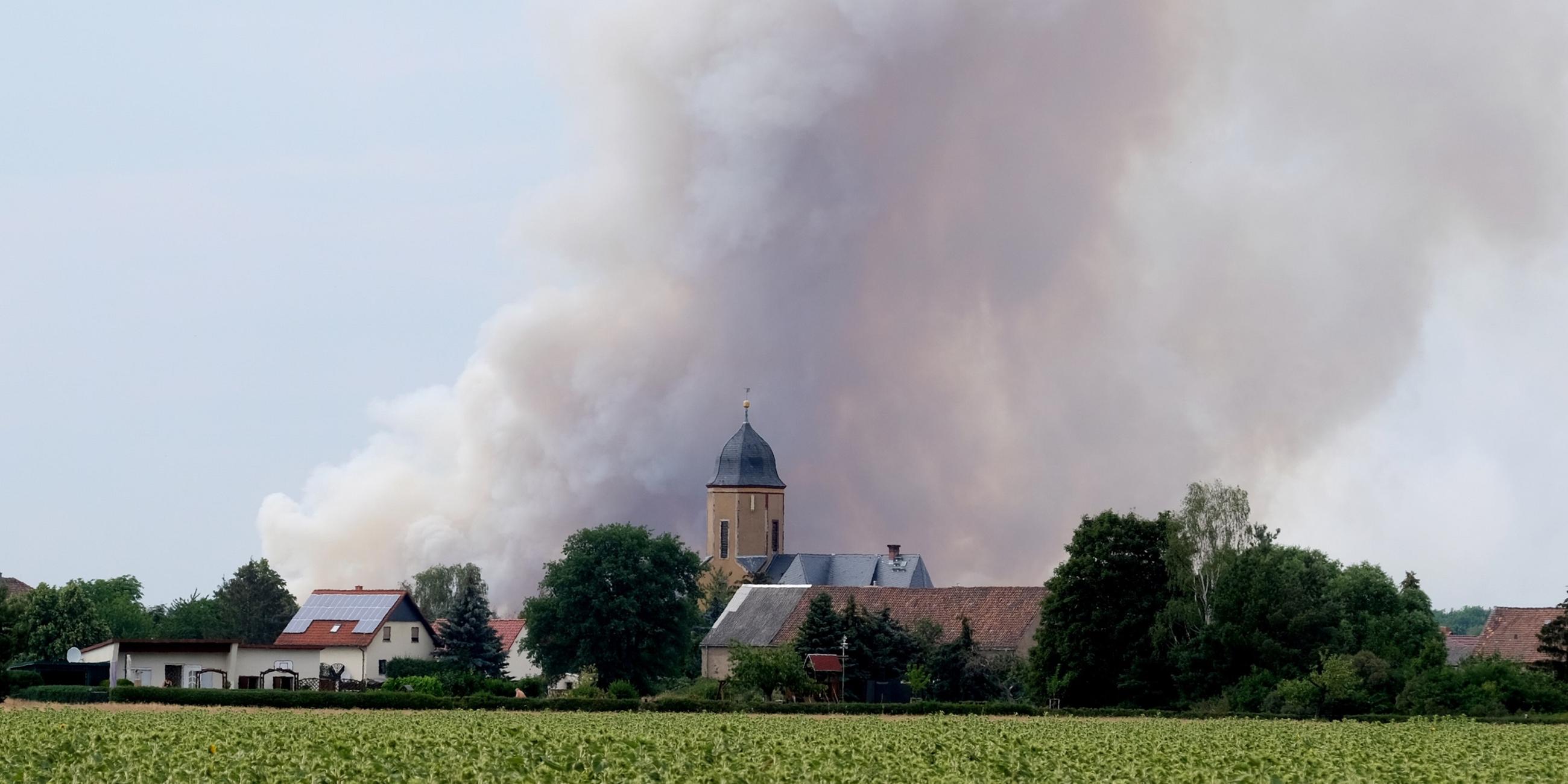 Sachsen, Wülknitz: Rauch eines Waldbrandes steigt über dem Dorf Lichtensee (Landkreis Meißen) auf.