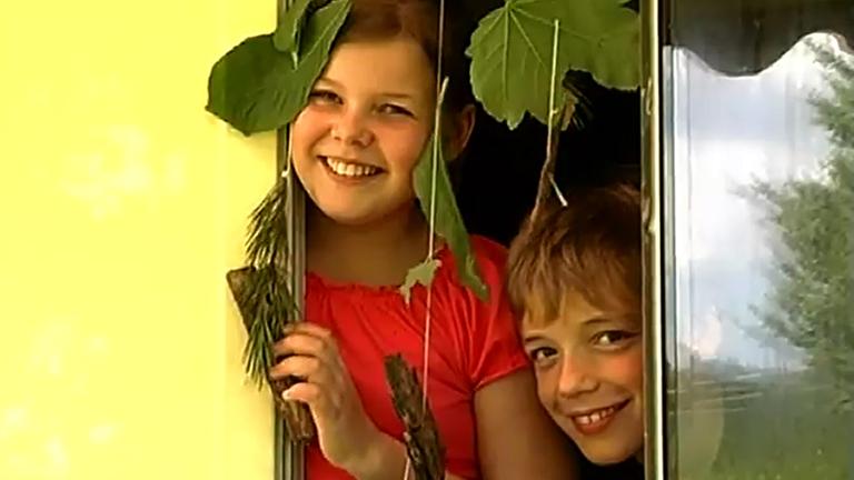 Die Kinder haben sich einen Vorhang aus Dingen aus dem Wald gebastelt
