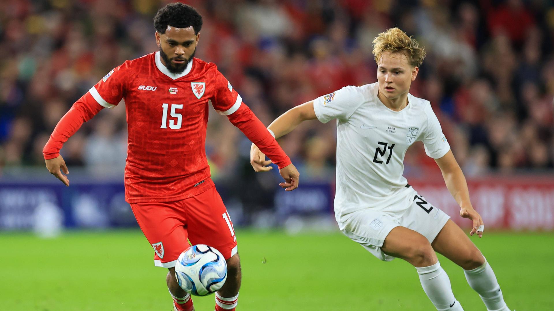 Der norwegische Nationalspieler Morten Hjulmand verfolgt den ballführenden walisischen Nationalspieler Jay Dasilva.