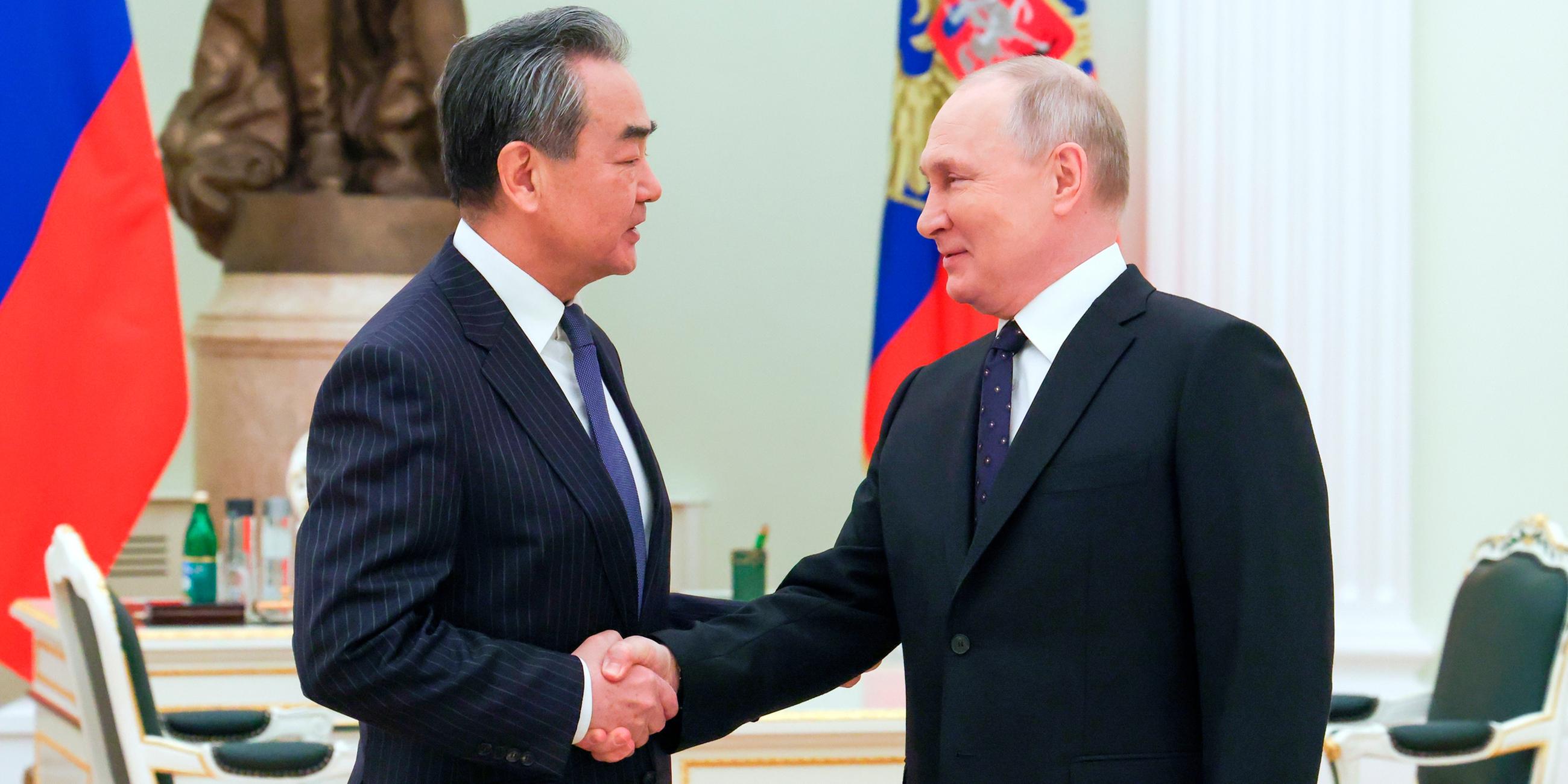 Wang Yi und Wladimir Putin