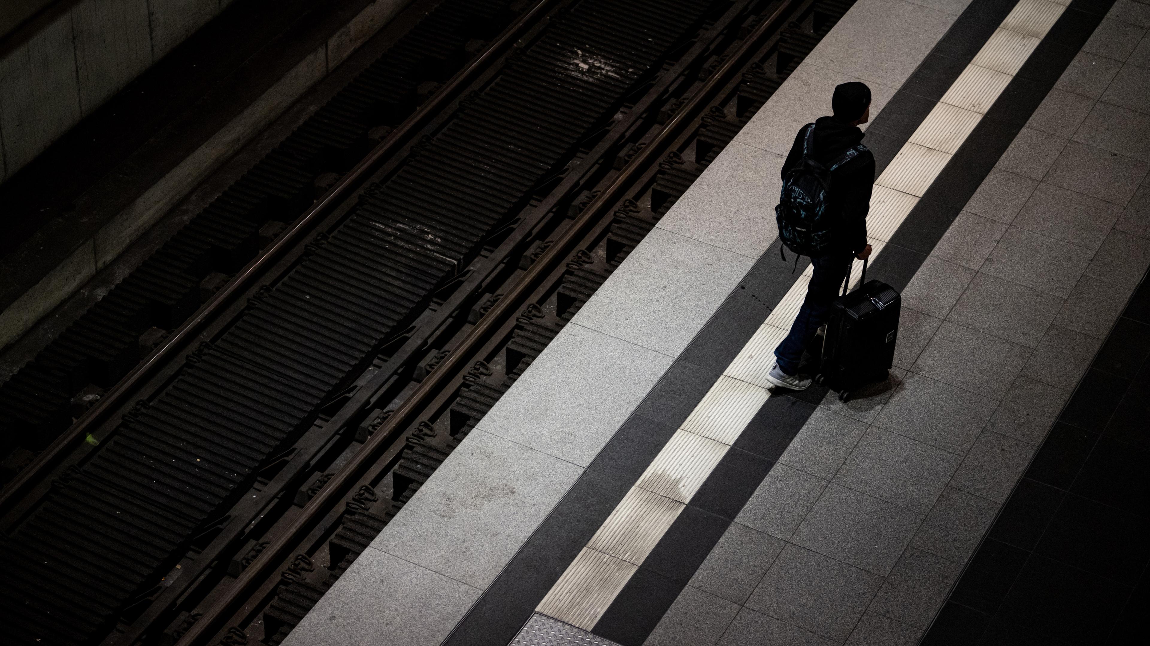 Eine Person steht am frühen Morgen beim Warnstreik bei der Bahn mit Koffer am Berliner Hauptbahnhof. 
