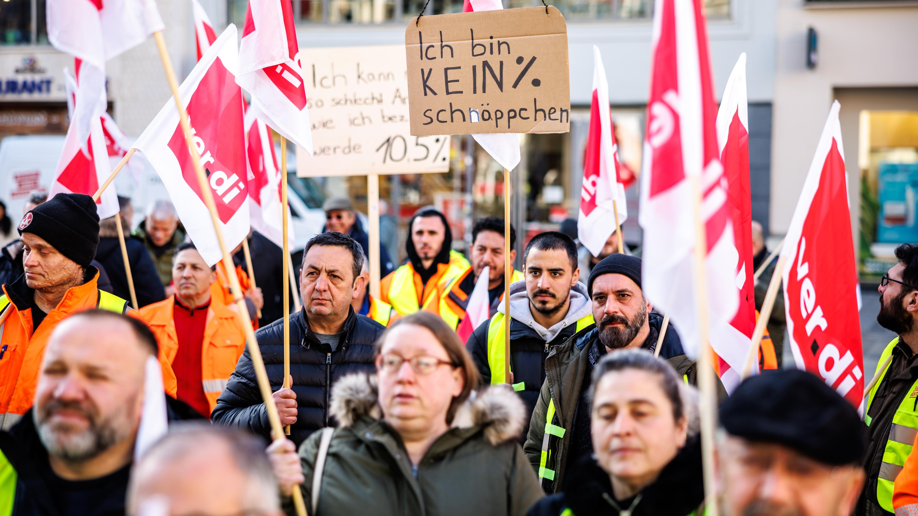 Menschen mit Schildern und Fahnen stehen auf dem Münchner Marienplatz und streiken