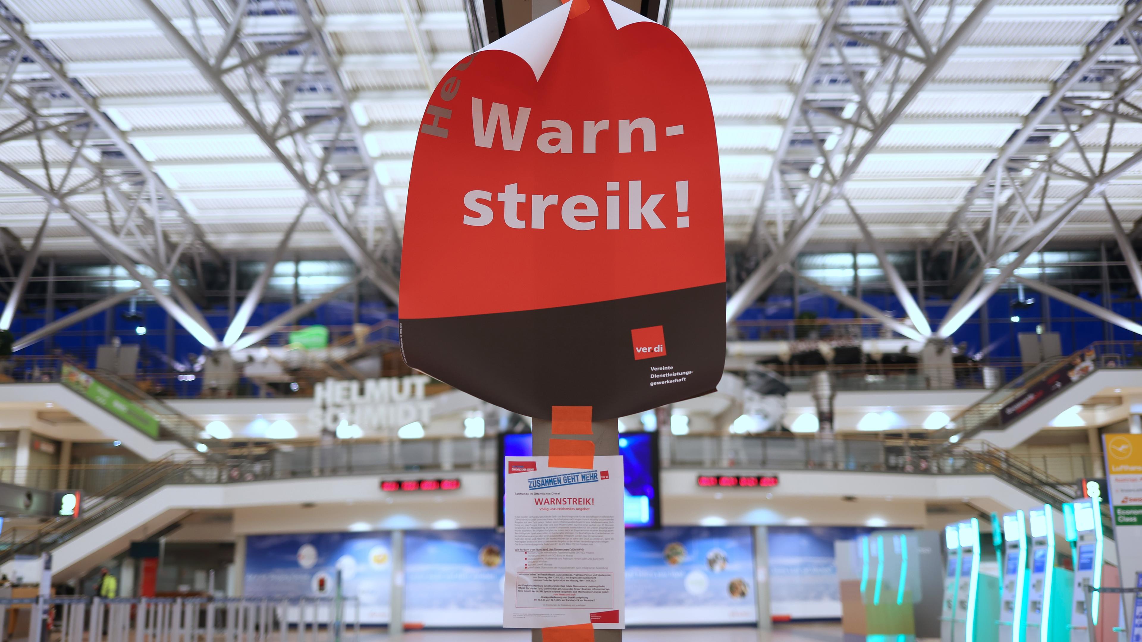 Hamburg: Ein Plakat mit dem Text "Warnstreik!" hängt im menschenleeren Terminal 2 im Flughafen Hamburg.