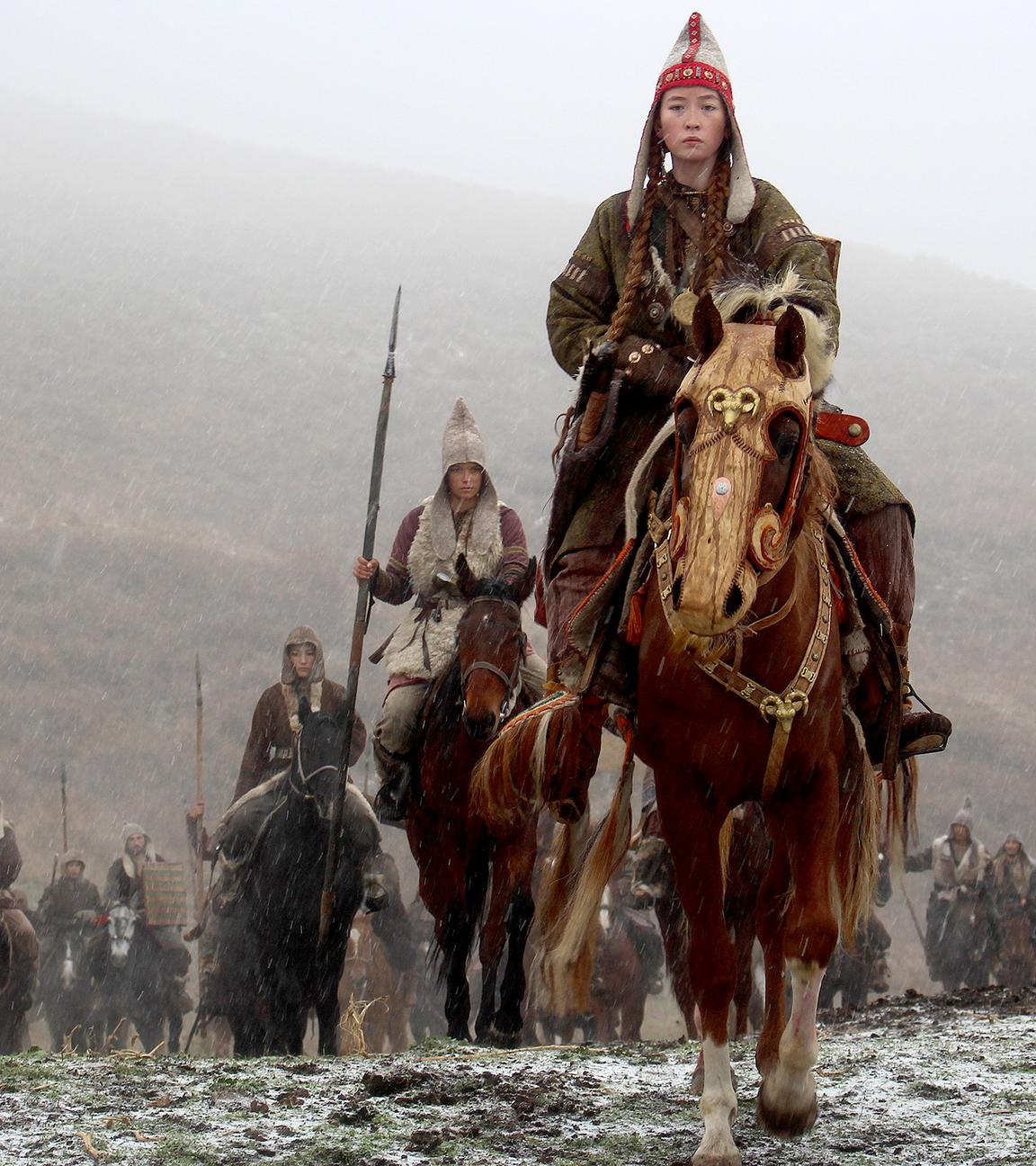 Anführerin Alkaya führt ihren Stamm in den Krieg. Sie reiten auf Pferden.