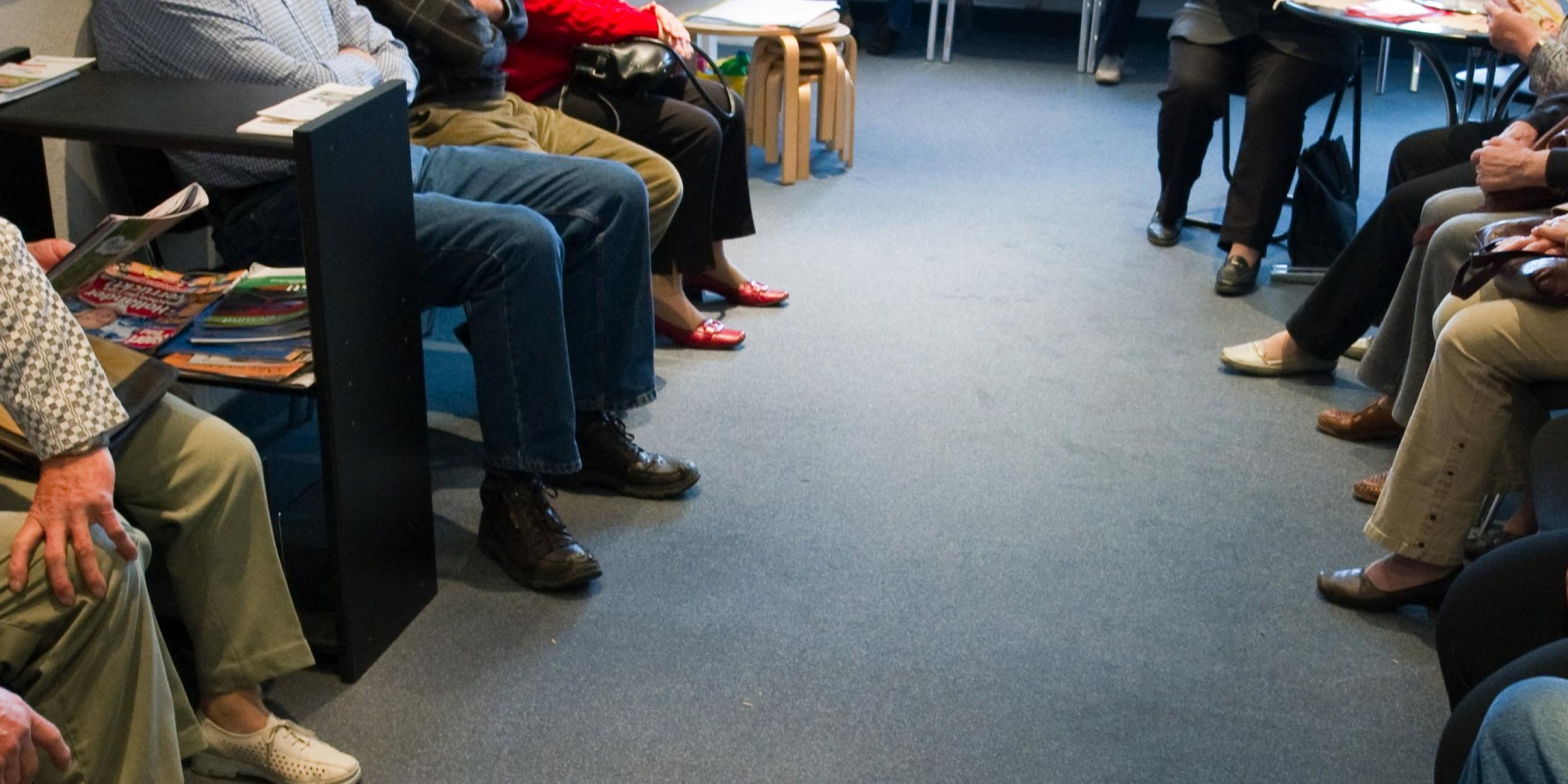 Patienten sitzen in einem Wartezimmer einer Praxis