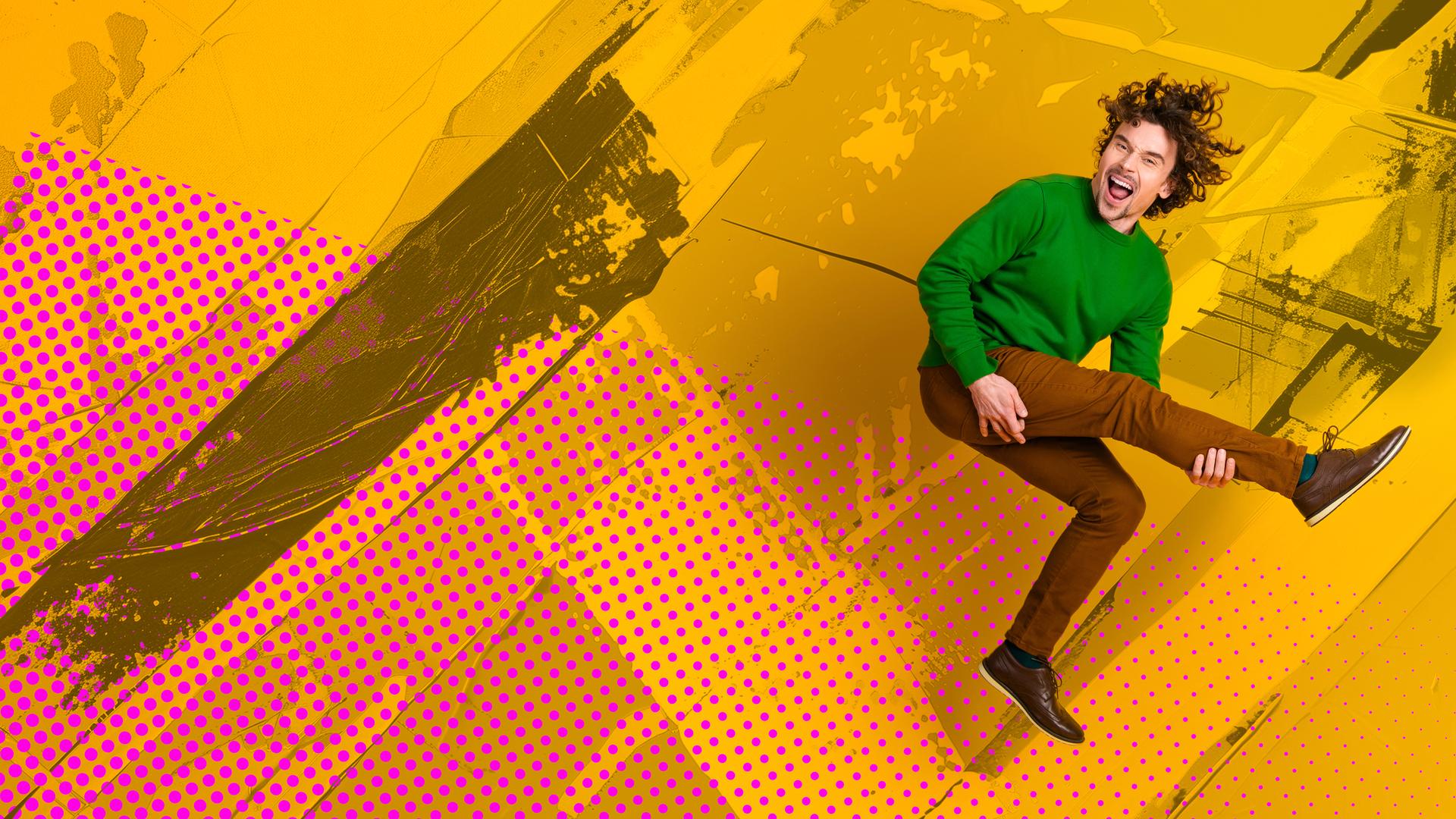 Mann, der in die Luft springt und mit einem seiner Beine eine Gitarre simuliert.