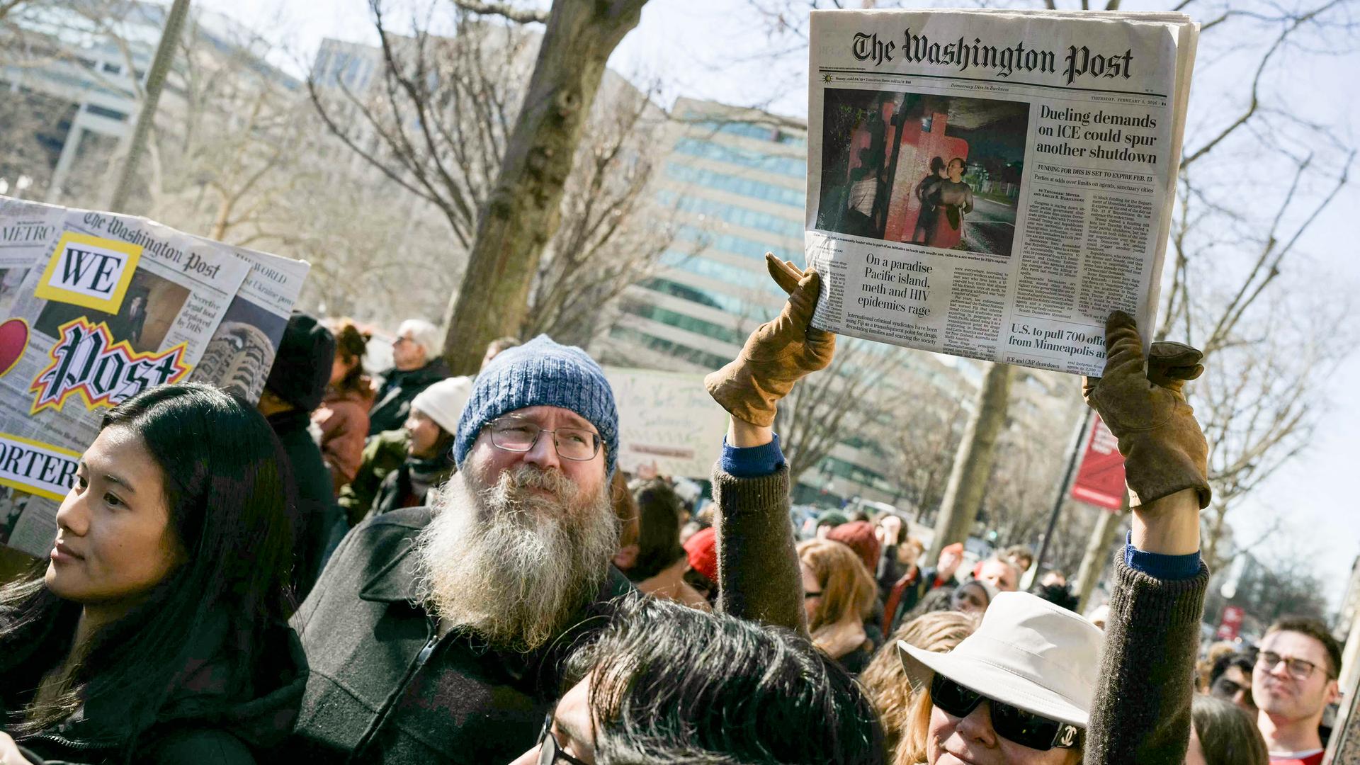 Demonstranten halten ein Exemplar der Zeitung Washington Post und Plakate hoch.