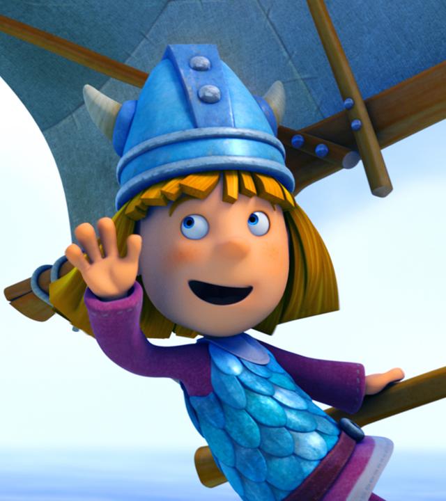 Wickie hat Spaß beim Segeln und winkt jemandem zu.