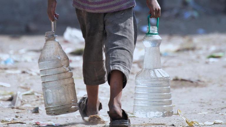 Archiv: Ein Kind holt am 19.03.2017 in Lahore, Pakistan, mit provisorischen Transportbehältern Wasser vom Fluß Ravi