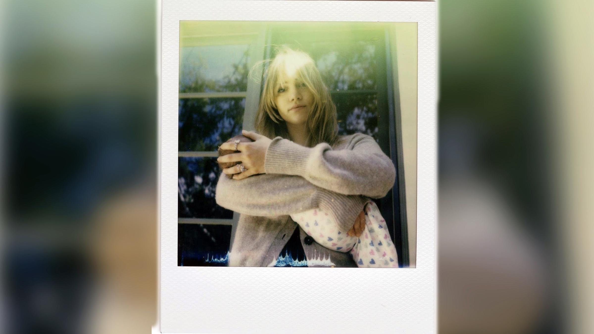 Ein Polaroidfoto zeigt Suki Waterhouse mit ihrem Kind auf dem Arm.
