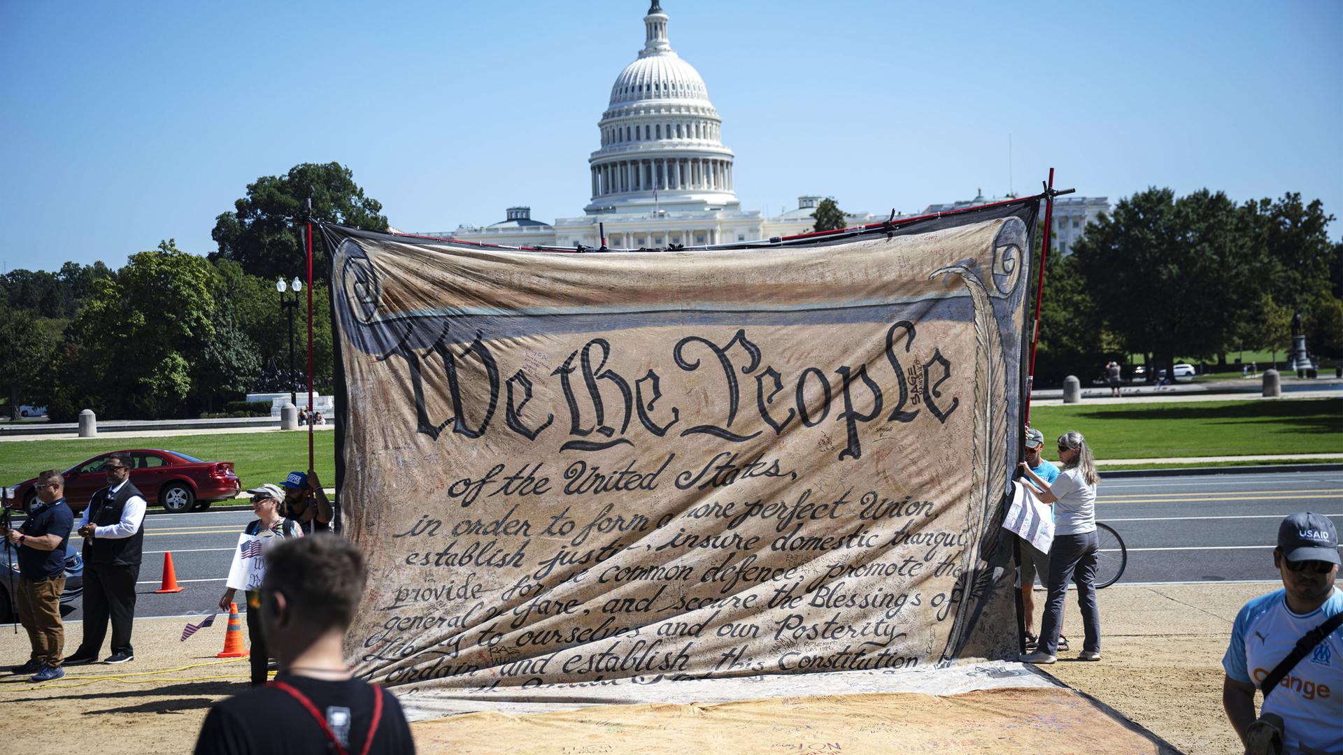 Plakat mit der Handschrift der ersten Seite der US-Verfassung "We The People" vor Weißem Haus in Washington