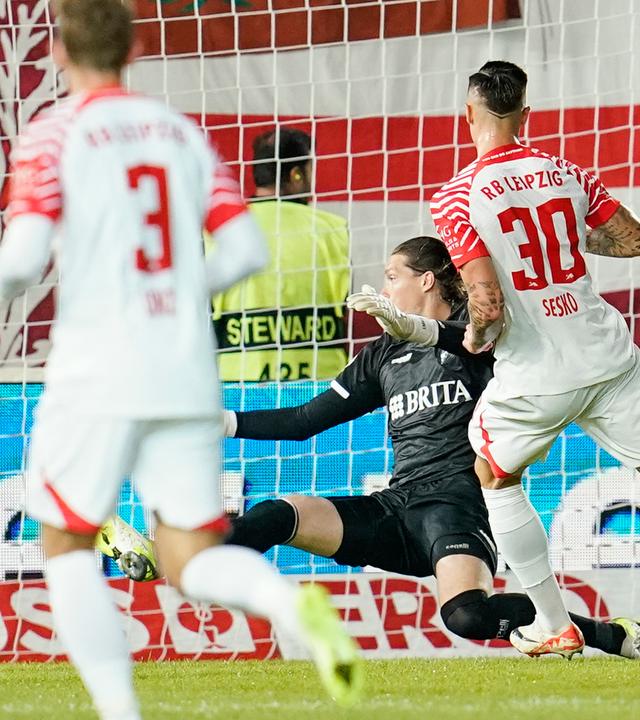 DFB-Pokal, SV Wehen Wiesbaden - RB Leipzig, 1. Runde: Leipzigs Benjamin Sesko (r.) schießt an Wiesbadens Torwart Florian Stritzel vorbei das Tor zum 0:2.