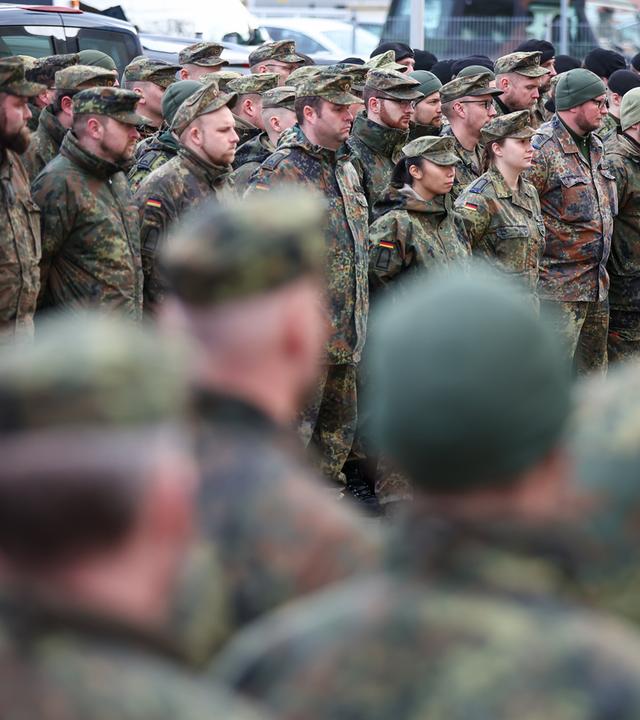 Bundeswehr Soldaten und Soldatinnen stehen vor ihrem Einsatz zusammen.