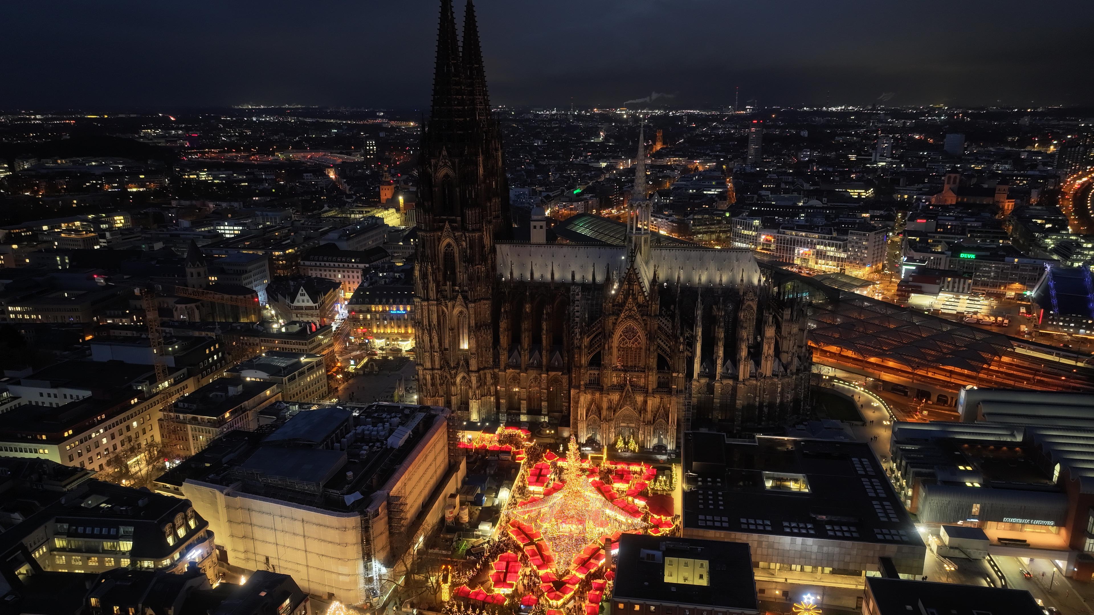 Luftaufnahme des Kölner Doms und des Weihnachtsmarktes am dem Roncalliplatz bei Nacht