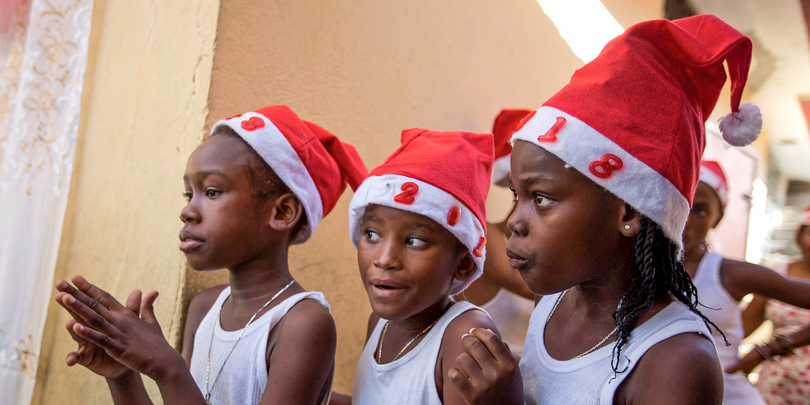 Drei Mädchen stehen am 22.12.2017 in Port-au-Prince (Haiti) während einer Weihnachtsveranstaltung hinter einer Bühne