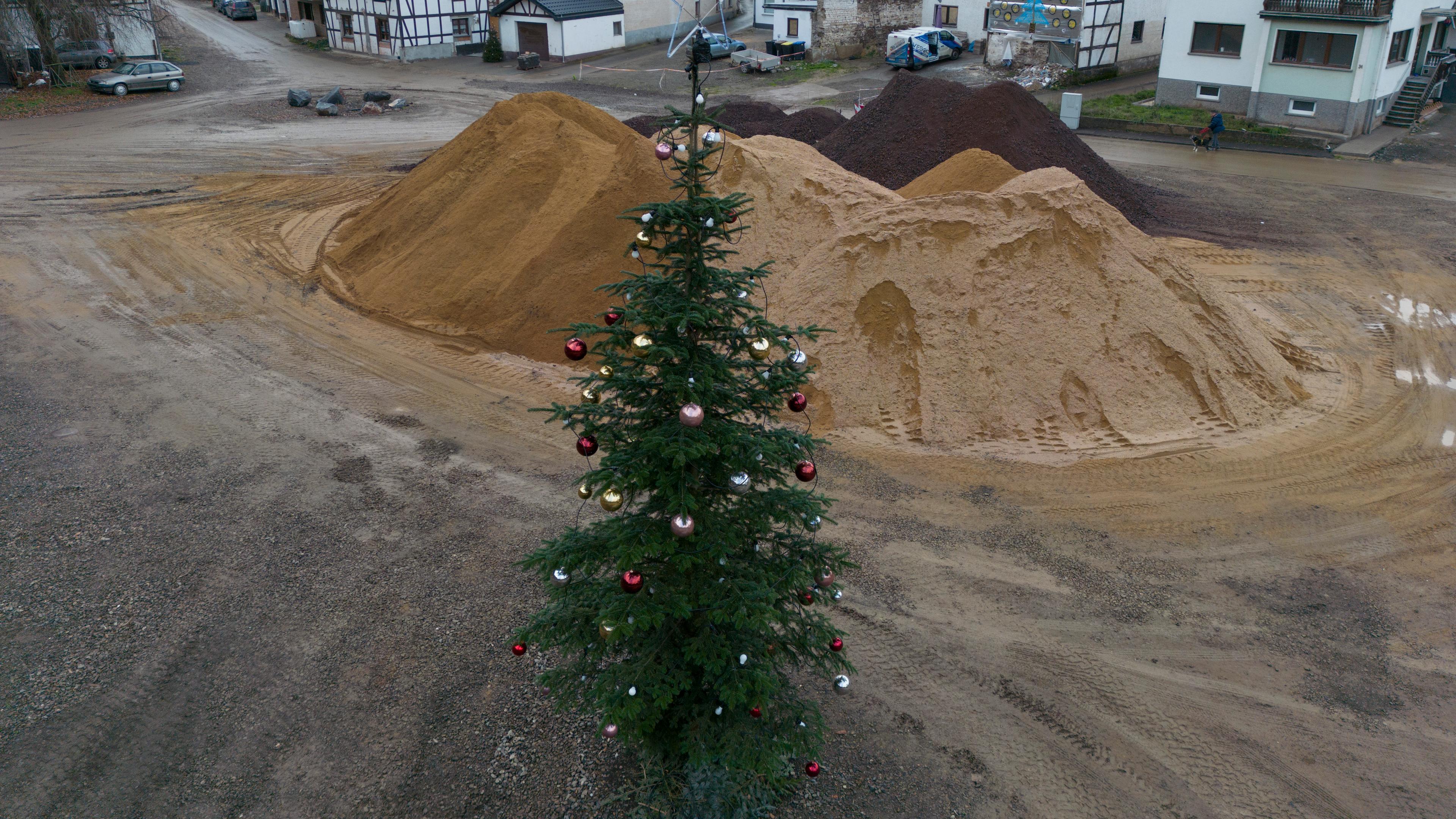 Ein geschmückter Weihnachtsbaum steht auf einer Brachfläche am Rande der Ahr in Schuld.