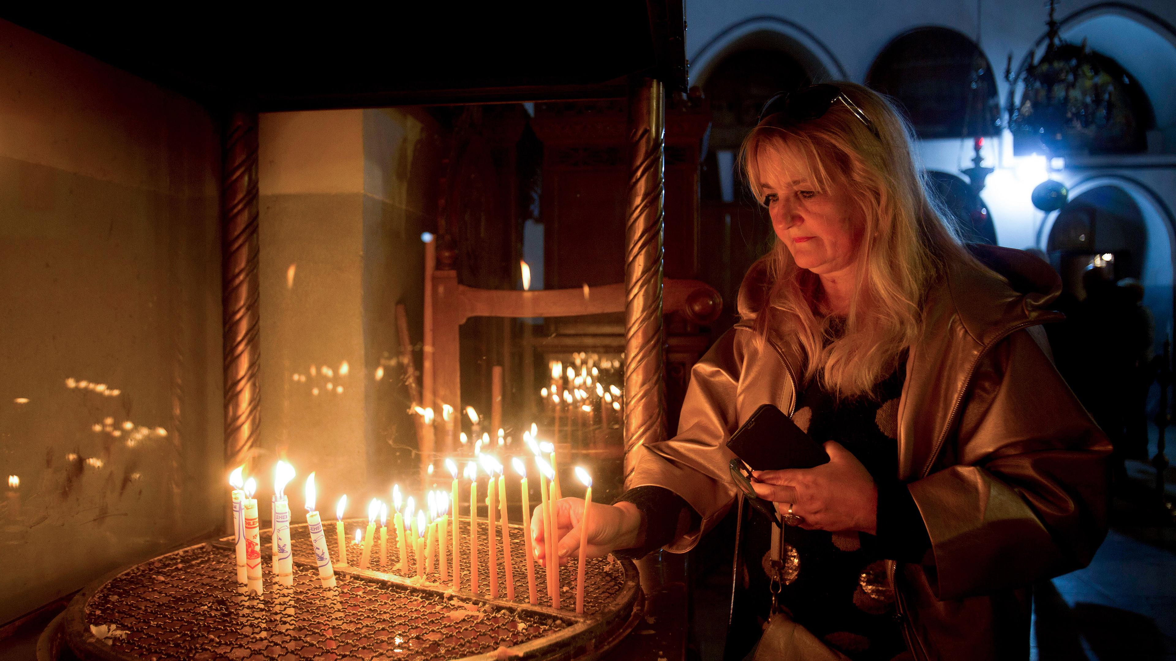 Eine Besucherin zündet eine Kerze in der Geburtskirche an, am 24.12.2019 in Bethlehem.