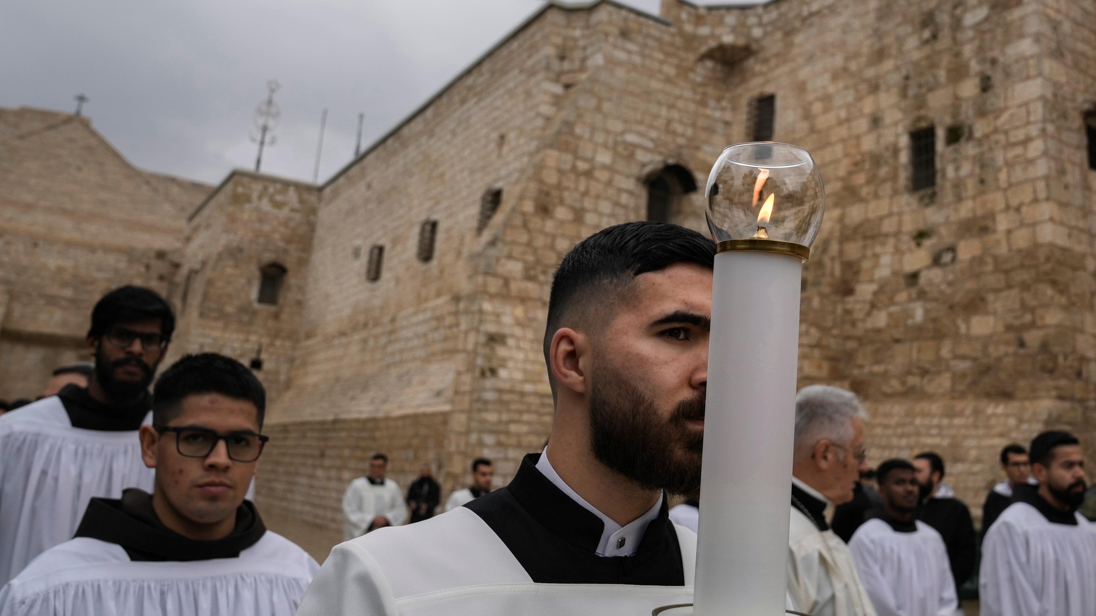 Katholische Geistliche gehen am Heiligabend in der Stadt Bethlehem im Westjordanland in einer Prozession neben der Geburtskirche.