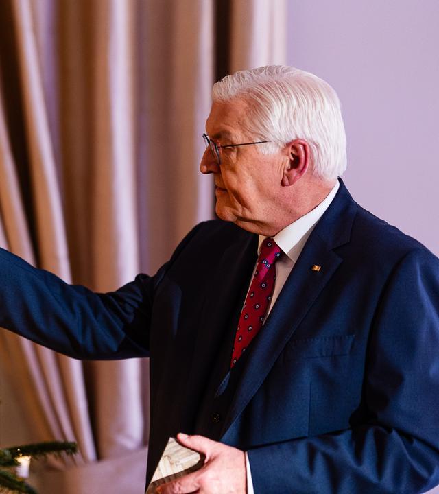 Bundespräsident Steinmeier zündet eine Kerze auf dem Weihnachtsbaum an.