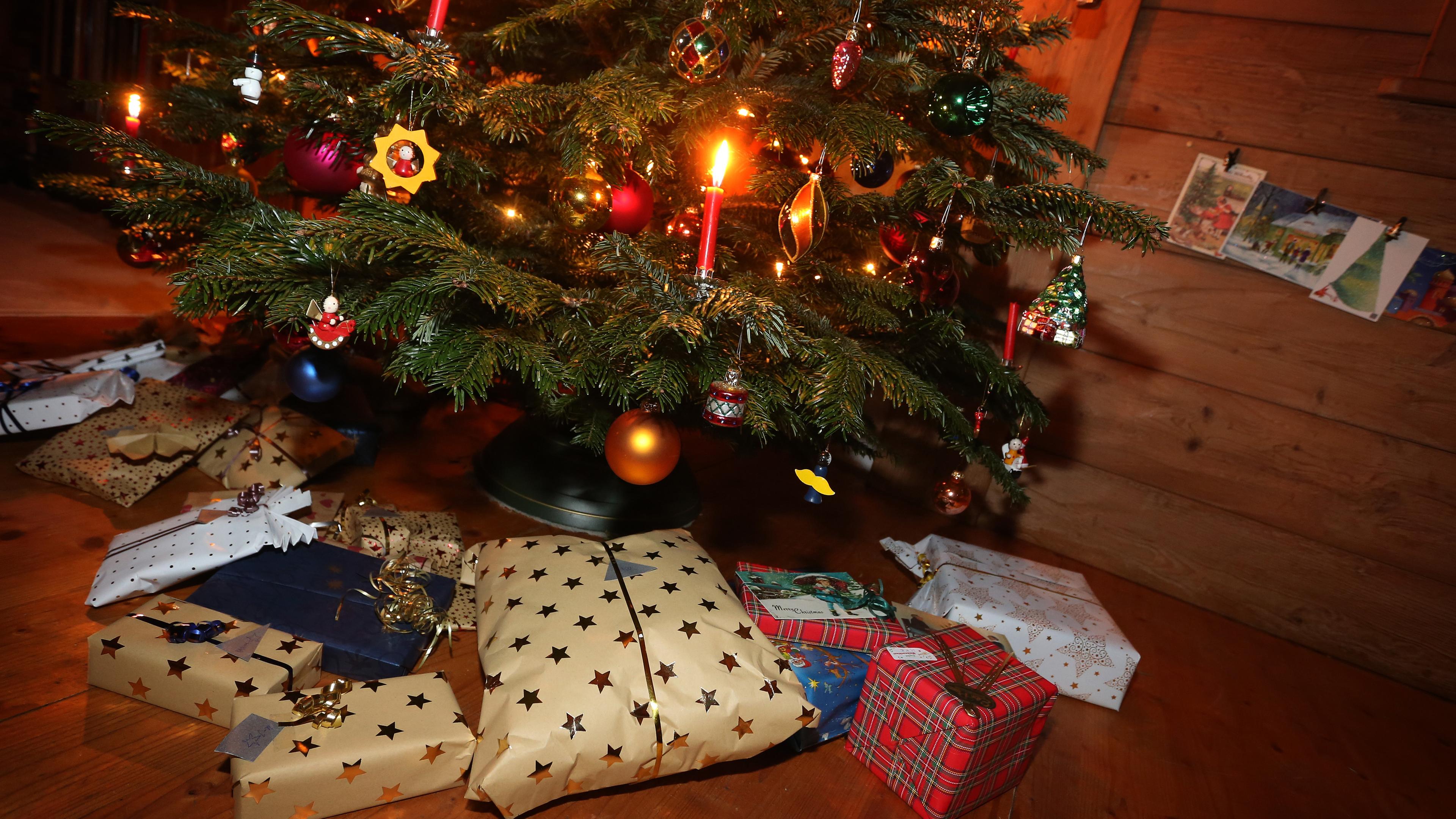 Unter einem geschmückten Weihnachtsbaum liegen eingepackte Geschenke.