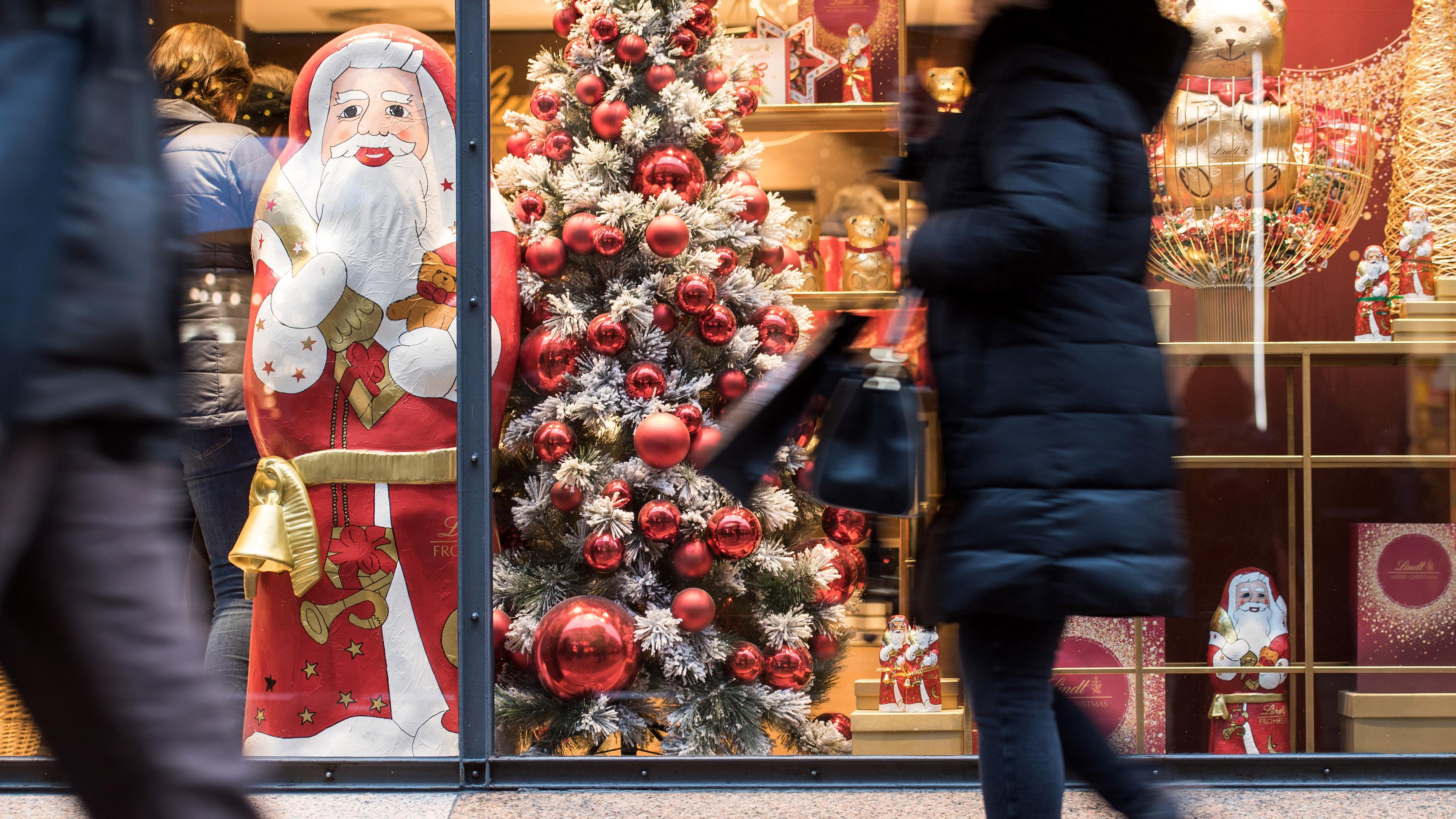 Eine Frau geht an einem weihnachtlich dekorierten Schaufenster entlang, Hamburg, 14.12.2019.