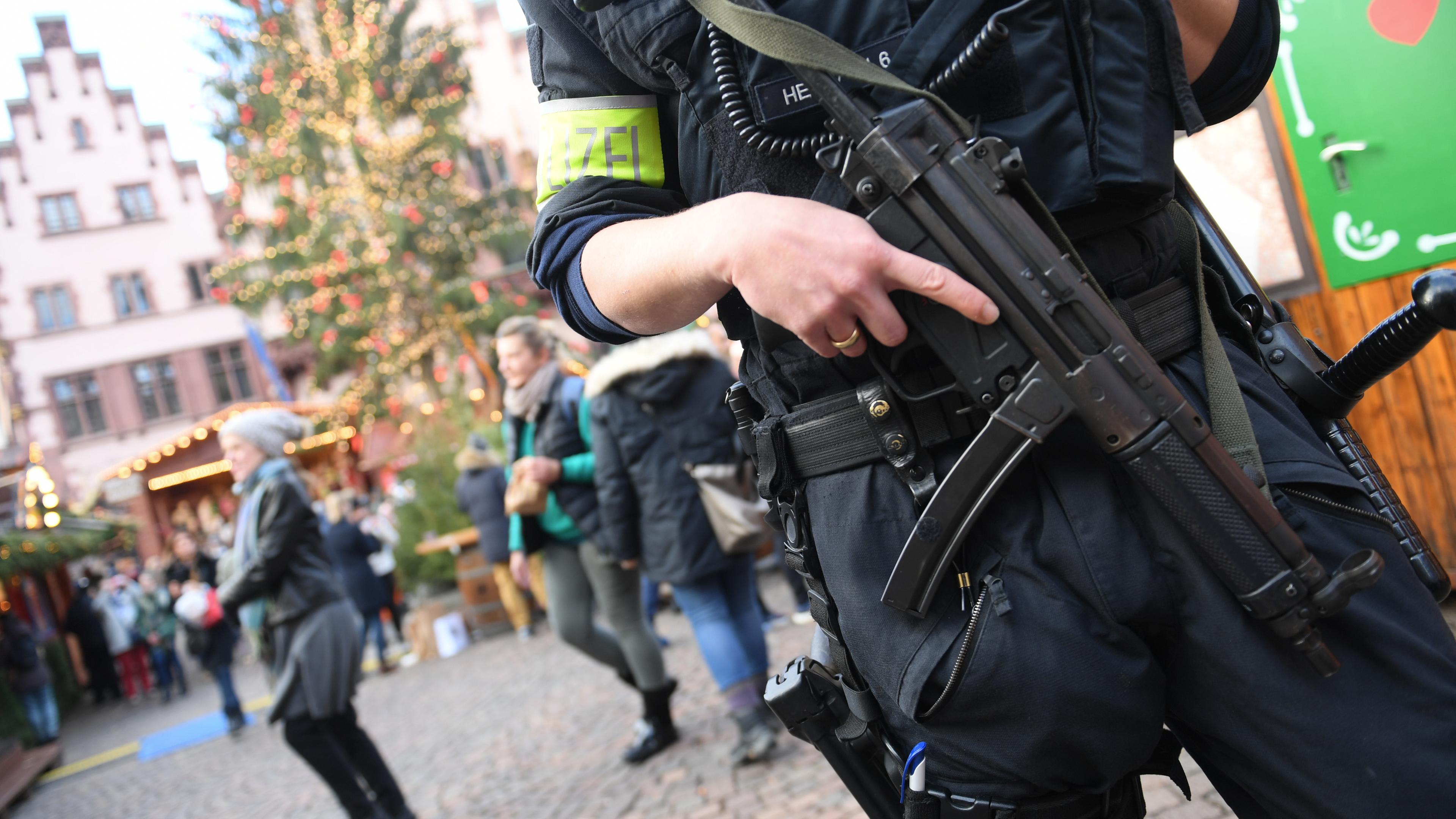 Ein Polizist steht während eines Streifengangs mit Maschinenpistole auf dem Frankfurter Weihnachtsmarkt.