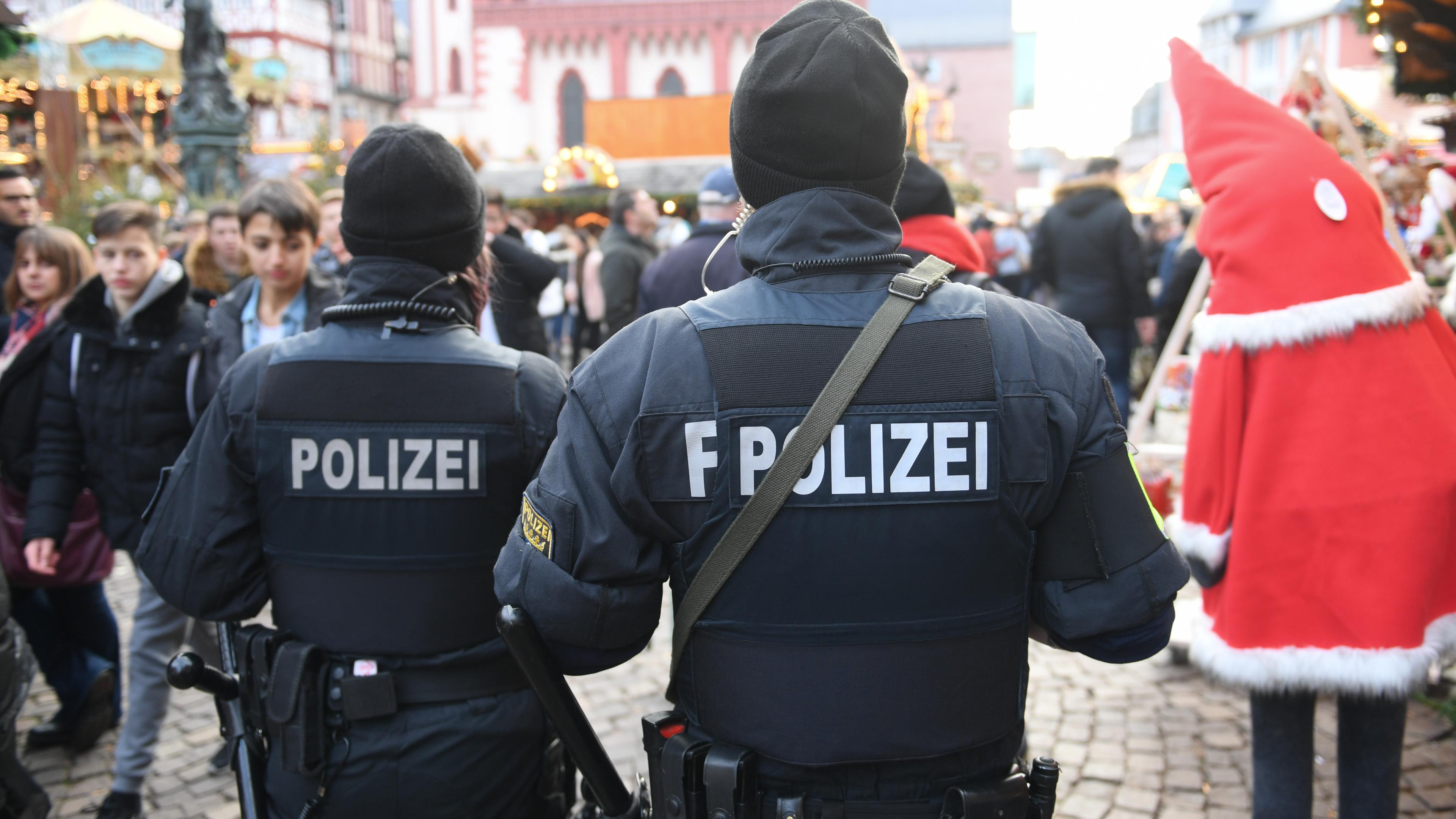 Eine Polizeibeamtin (l) geht auf dem Frankfurter Weihnachtsmarkt mit einem Kollegen Streife. 