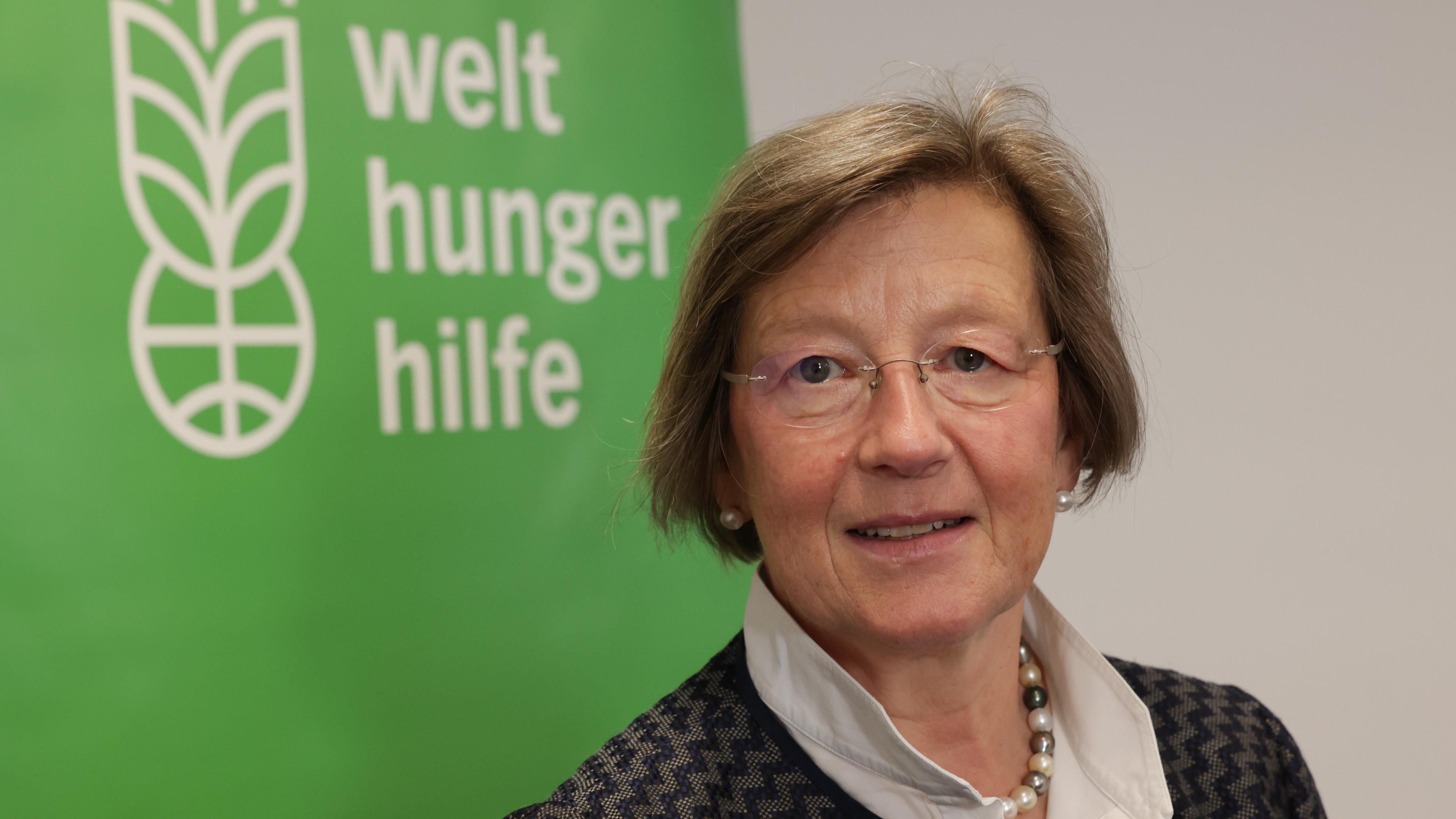 Marlehn Thieme, Präsidentin der Welthungerhilfe vor einem Schild mit Logo und Aufschrift "Welthungerhilfe".