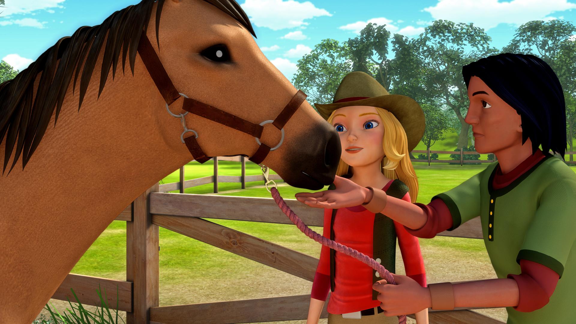 Wendy, der Besitzer des Pferds und das Pferd stehen auf der Koppel. Der Besitzer nähert sich seinem Pferd mit der Hand.