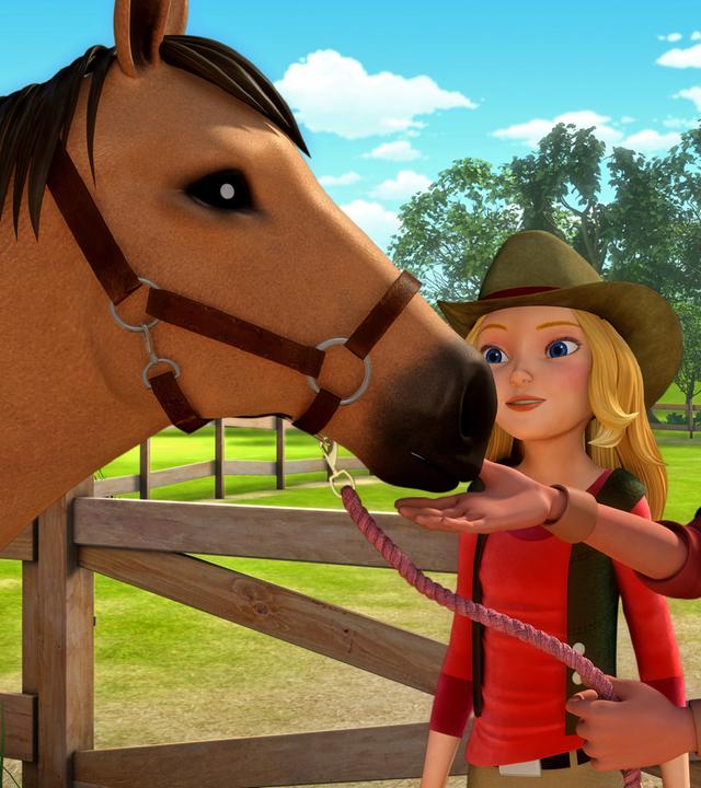 Wendy, der Besitzer des Pferds und das Pferd stehen auf der Koppel. Der Besitzer nähert sich seinem Pferd mit der Hand.