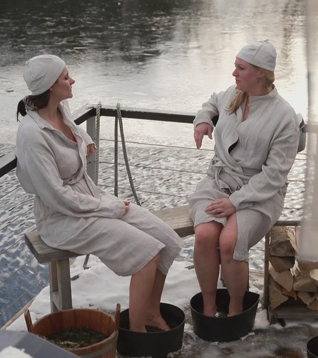 Auf dem Bild sieht man zwei Frauen auf mobiler Sauna auf der Spree.