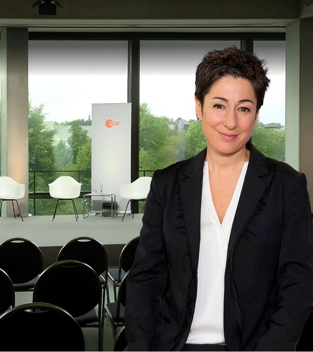 Dunja Hayali vor einem Podium