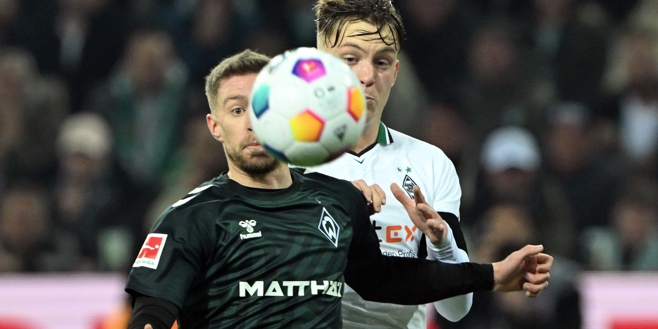 Werder Bremens Mitchell Weiser (l.) und Luca Netz (Mönchengladbach) am 15.12.2023 im Zweikampf