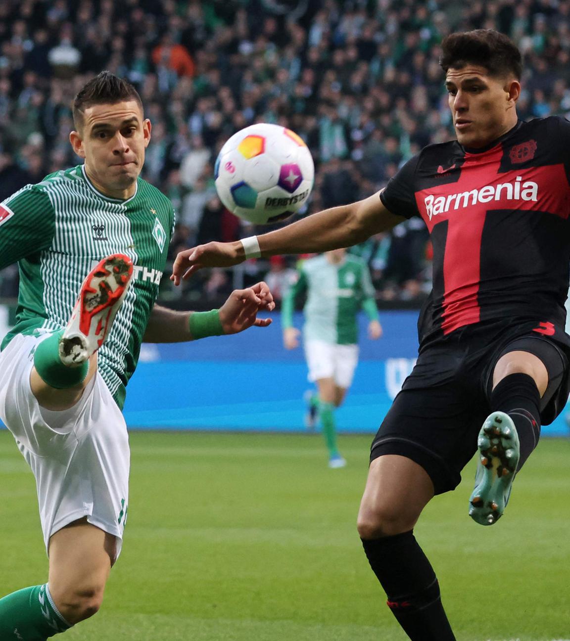 Rafael Borre (Werder Bremen, l) und Piero Hincapie (Bayer Leverkusen, r) kämpfen um den Ball.