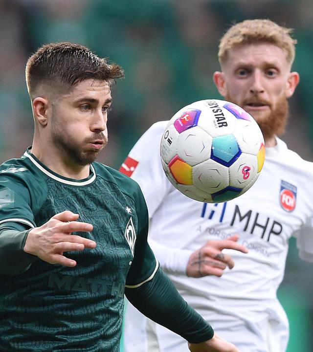 Werders Romano Schmid (l) kämpft gegen Heidenheims Jan-Niklas Beste um den Ball.