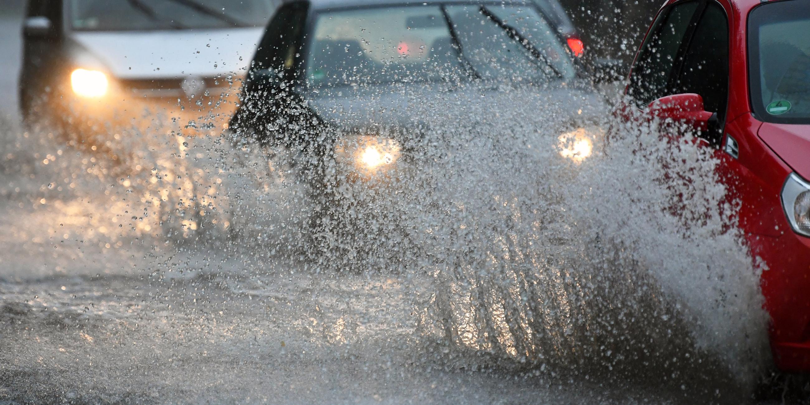 Autos fahren über eine überflutete Straße