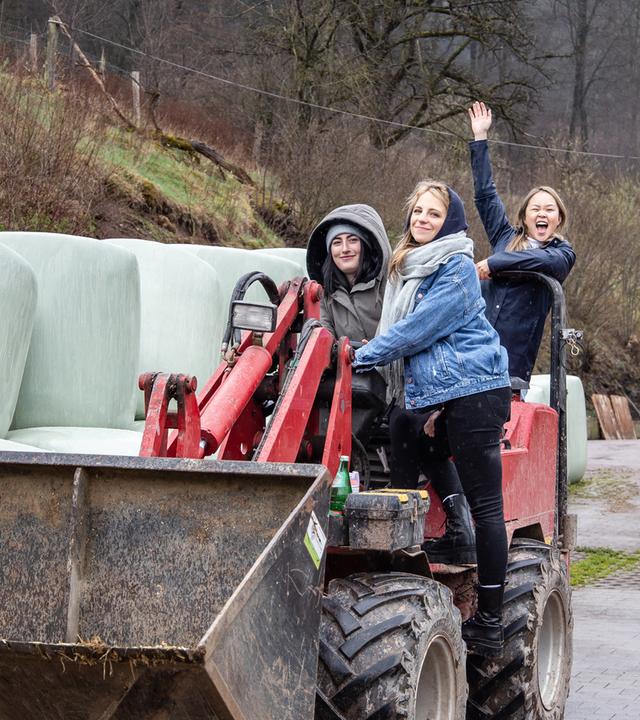 Alina, Janina und My fahren auf einem Radlader