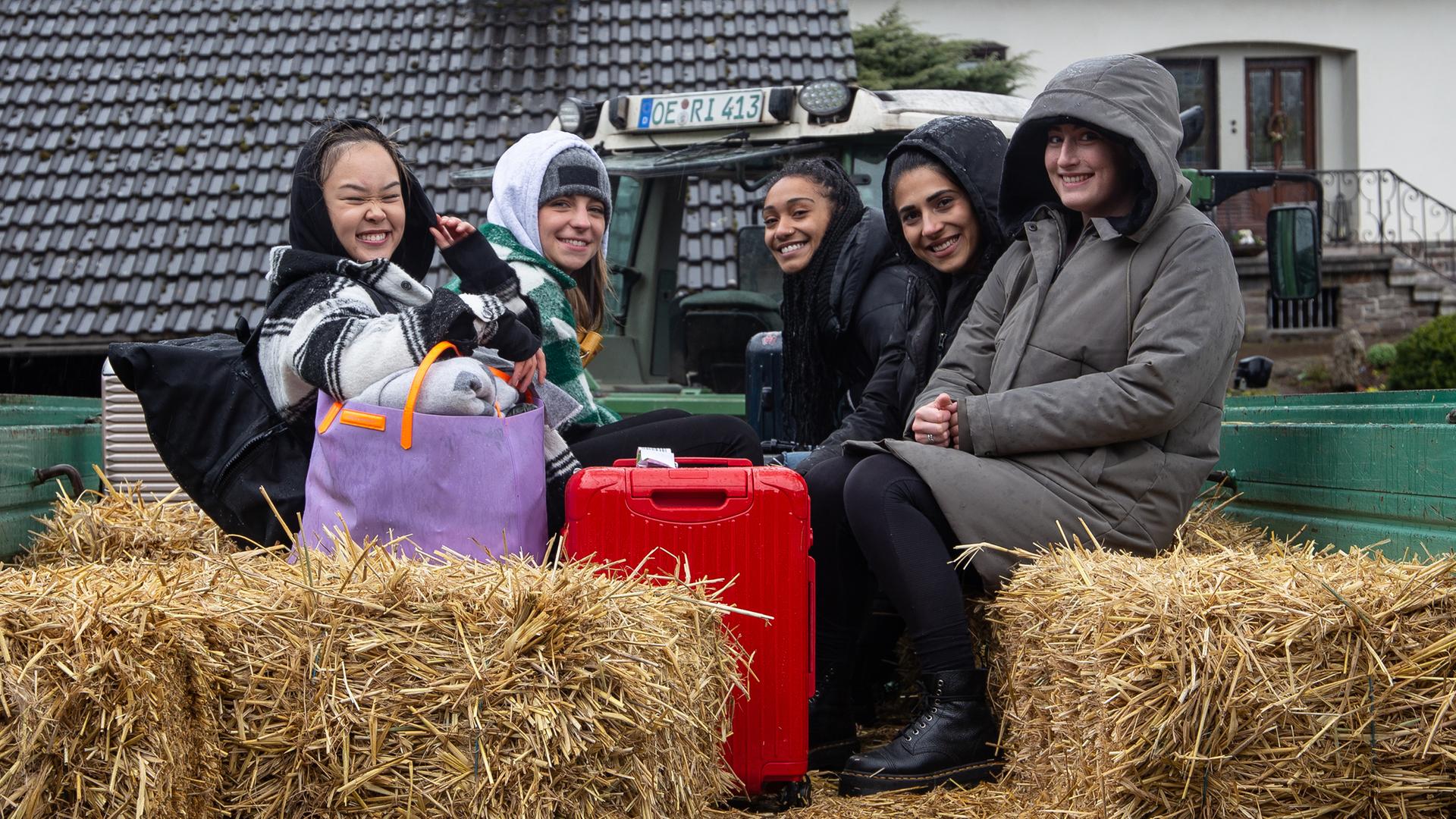 Alina, Feli, Hilla, Janina und My sitzen auf einem Traktoranhänger