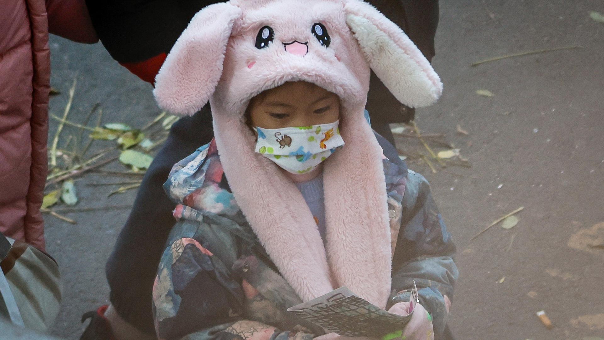 Ein kleines Kind mit einer Atemschutzmaske in Peking.